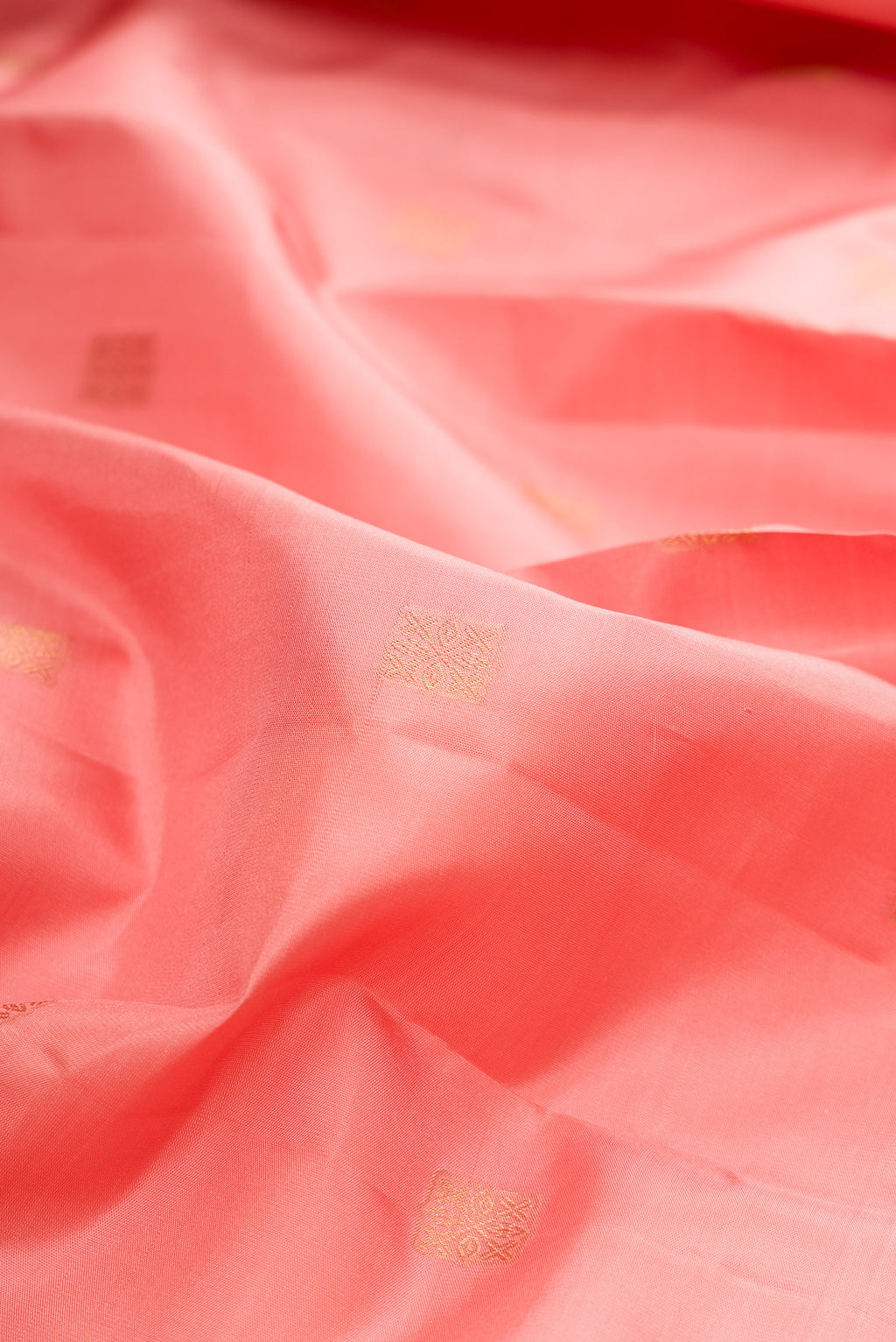 Close up of Pure Silk Peach Kanchipuram Saree with Zari Butta on the body and Zari Border.  displaying folds