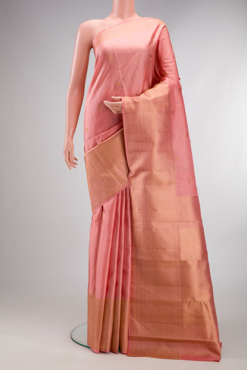 Pure Silk Peach Kanchipuram Saree with Zari Butta on the body and Zari Border.  displayed on a mannequin