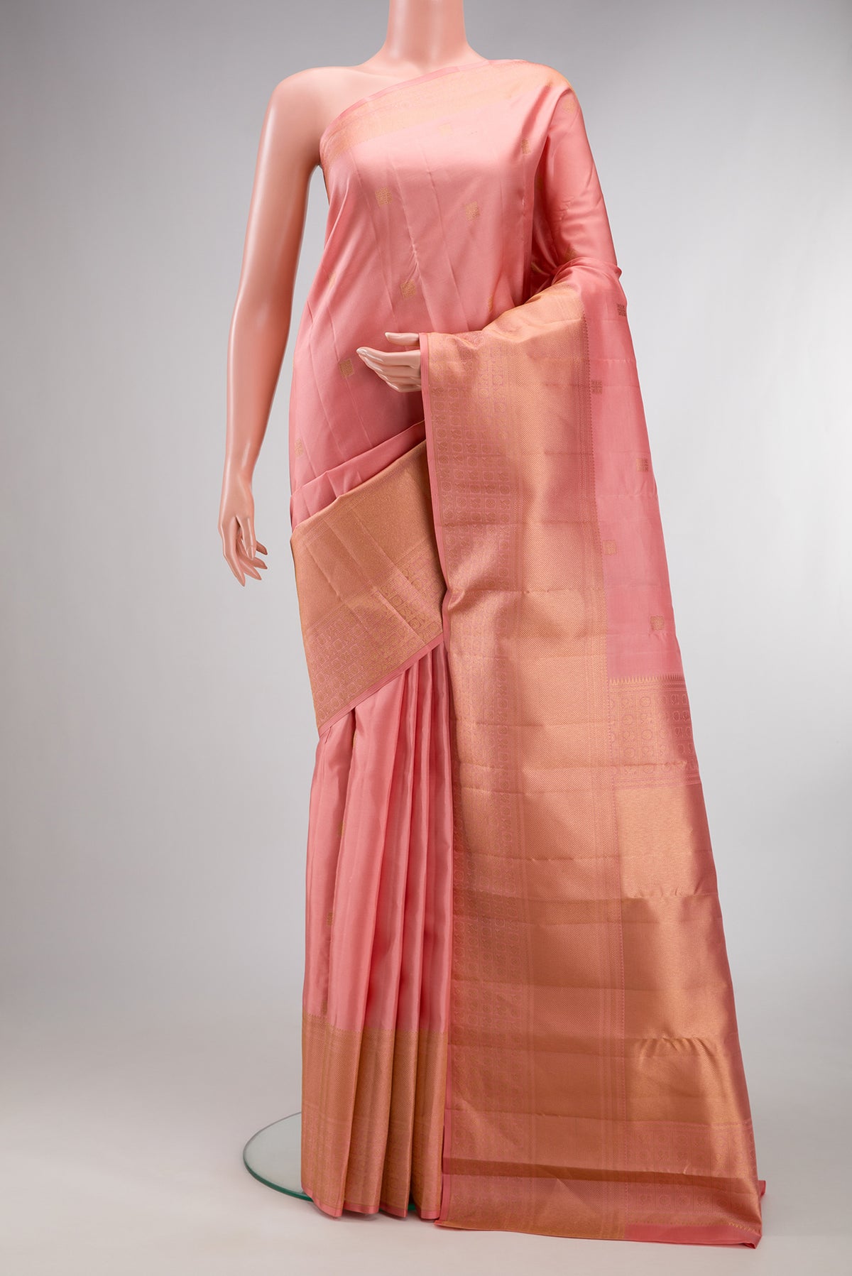Pure Silk Peach Kanchipuram Saree with Zari Butta on the body and Zari Border.  displayed on a mannequin