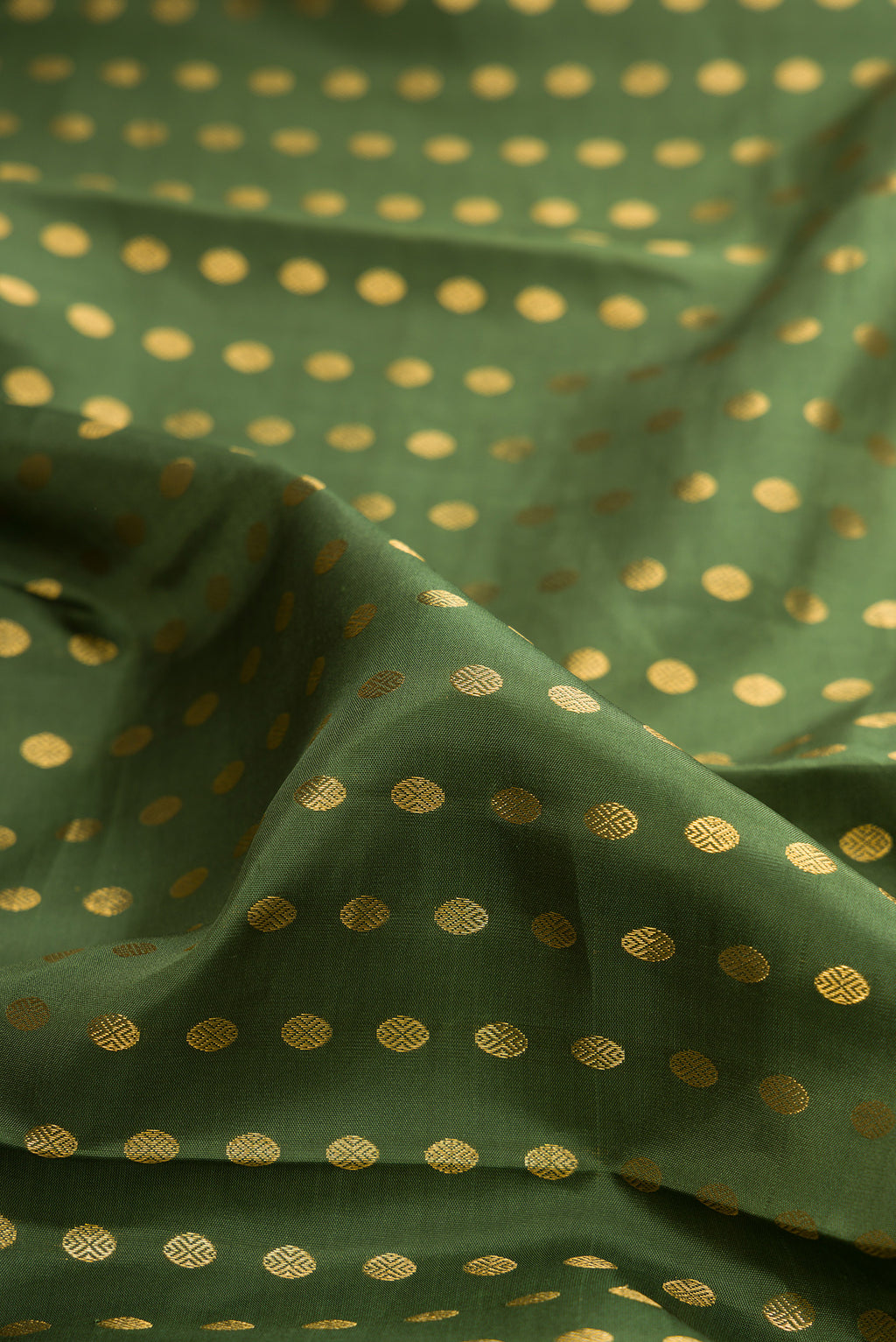 Close up of Pure Silk Mehandi Green Kanchipuram Saree with Zari Butta on the body and Zari Border.  displaying folds