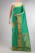 Pure Silk Green Kanchipuram Saree with Zari Butta on the body and Zari Border.  displayed on a mannequin
