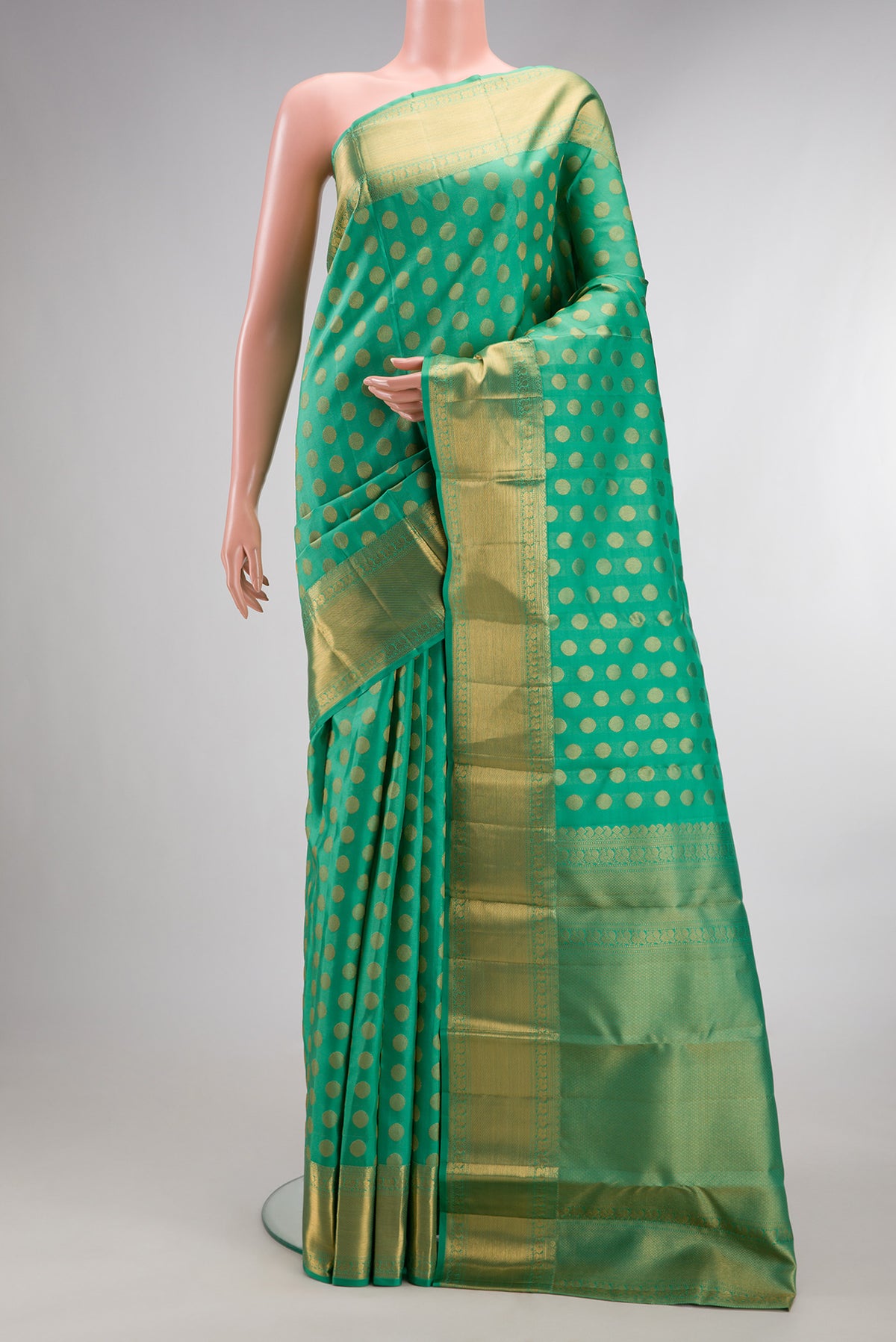 Pure Silk Green Kanchipuram Saree with Zari Butta on the body and Zari Border.  displayed on a mannequin