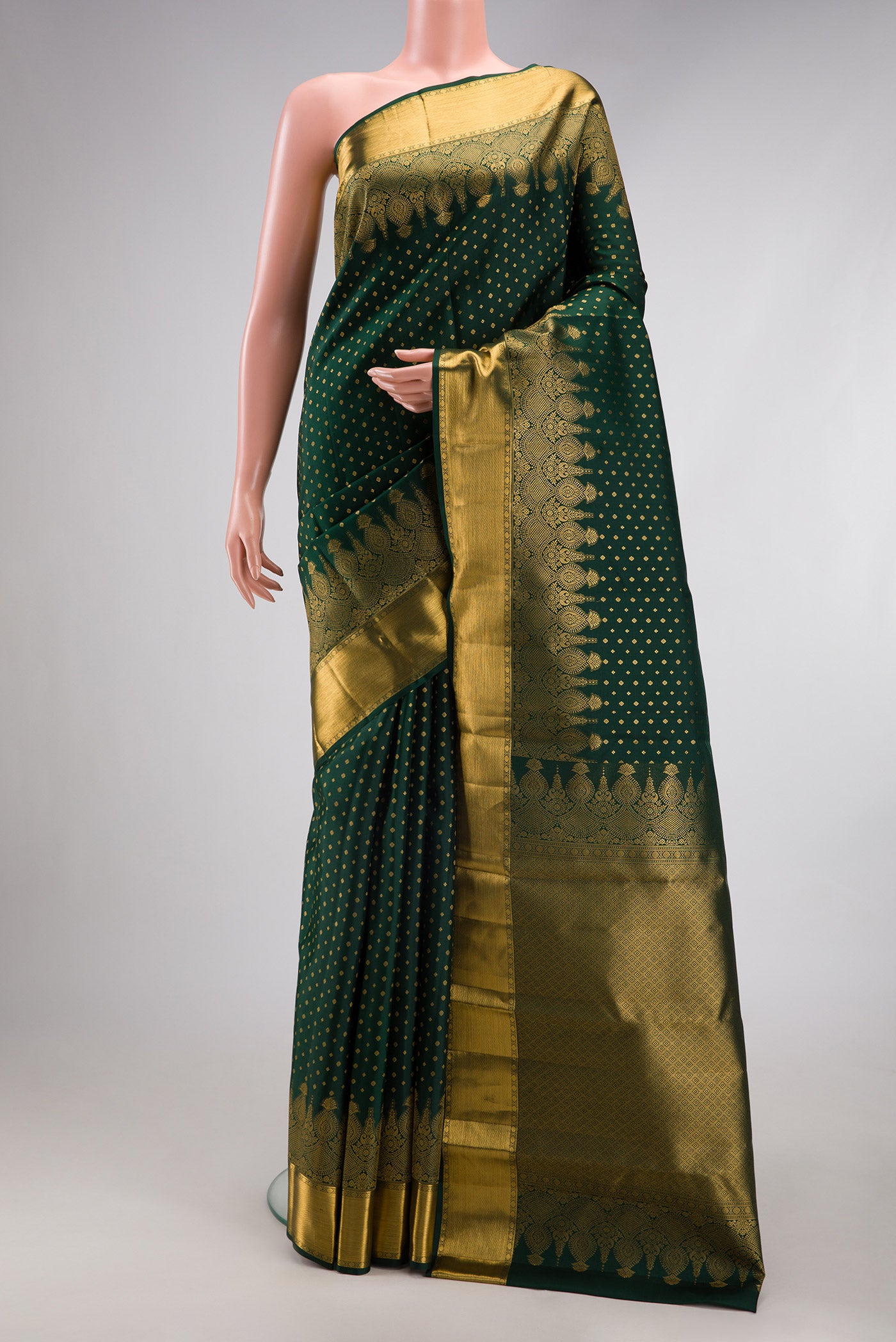 Bottle Green Kanjivaram Silk Saree with Zari Butta on the body and Fancy Border.  displayed on a mannequin
