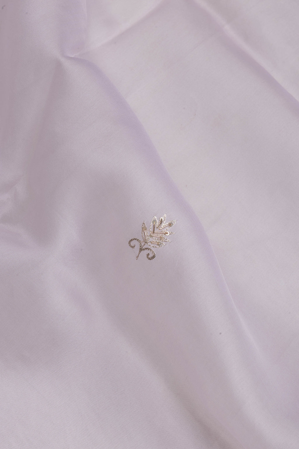 Close up of Lilac Organza Silk Saree with Embroidery on the body and Embroidery Border.  displaying folds