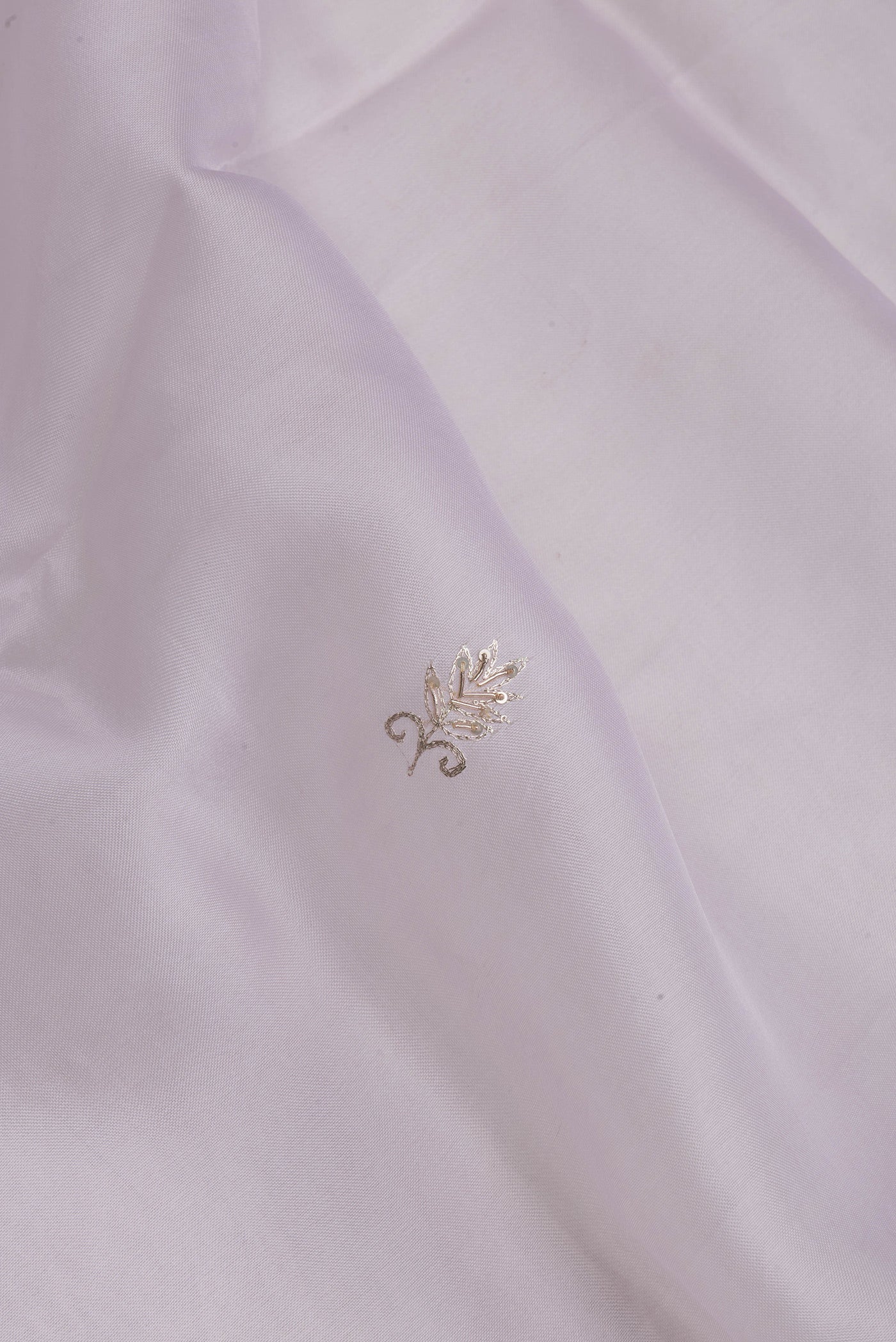 Close up of Lilac Organza Silk Saree with Embroidery on the body and Embroidery Border.  displaying folds