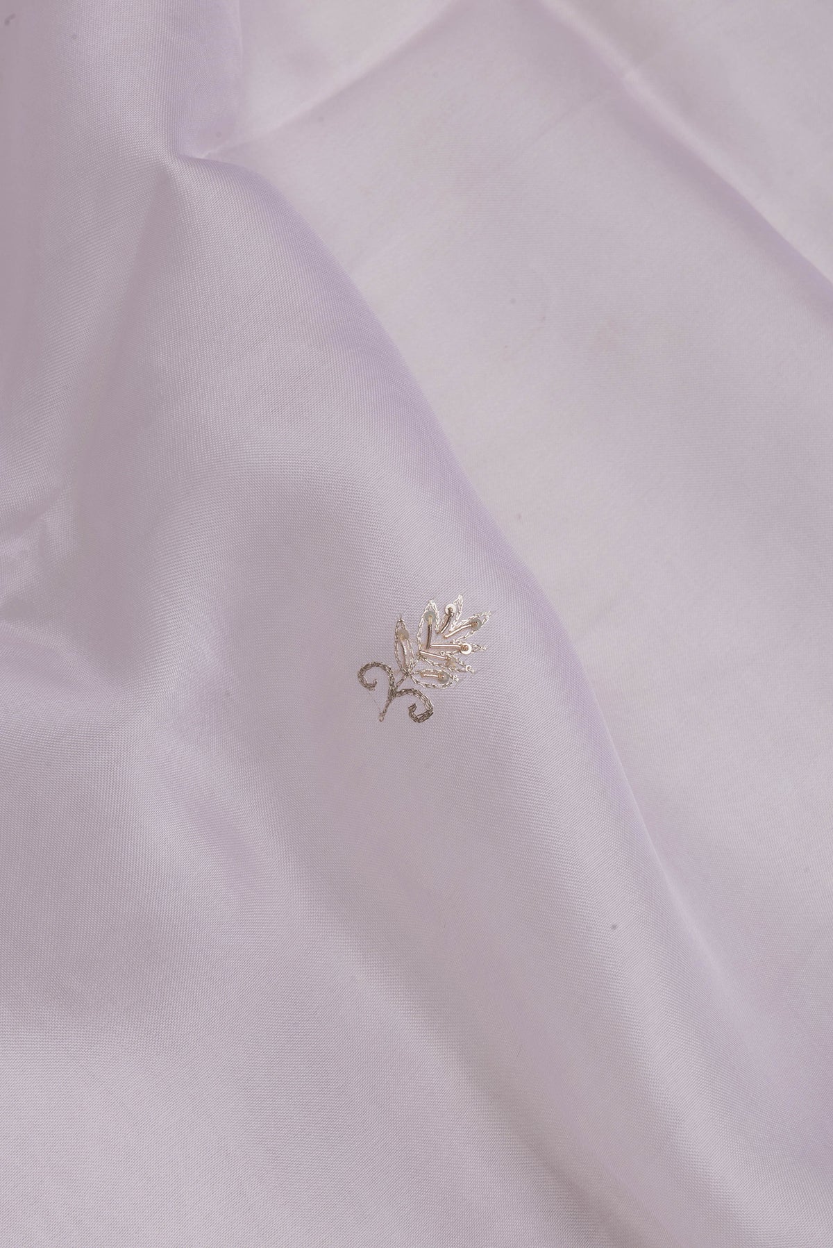 Close up of Lilac Organza Silk Saree with Embroidery on the body and Embroidery Border.  displaying folds