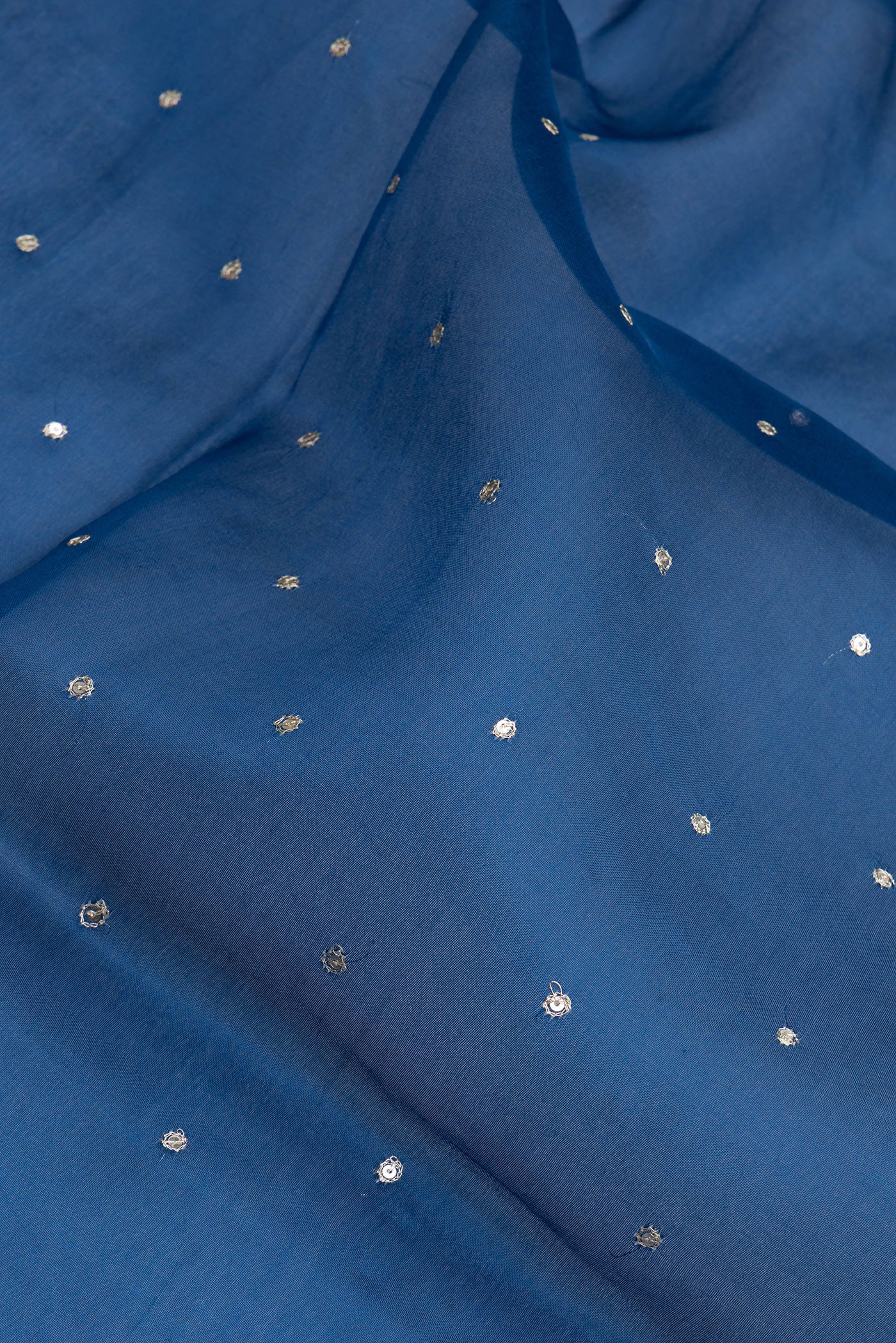 Close up of Blue Organza Silk Saree with Embroidery on the body and Embroidery Border.  displaying folds