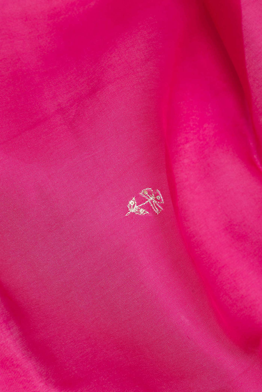 Close up of Dark Pink Organza Silk Saree with Embroidery on the body and Embroidery Border.  displaying folds