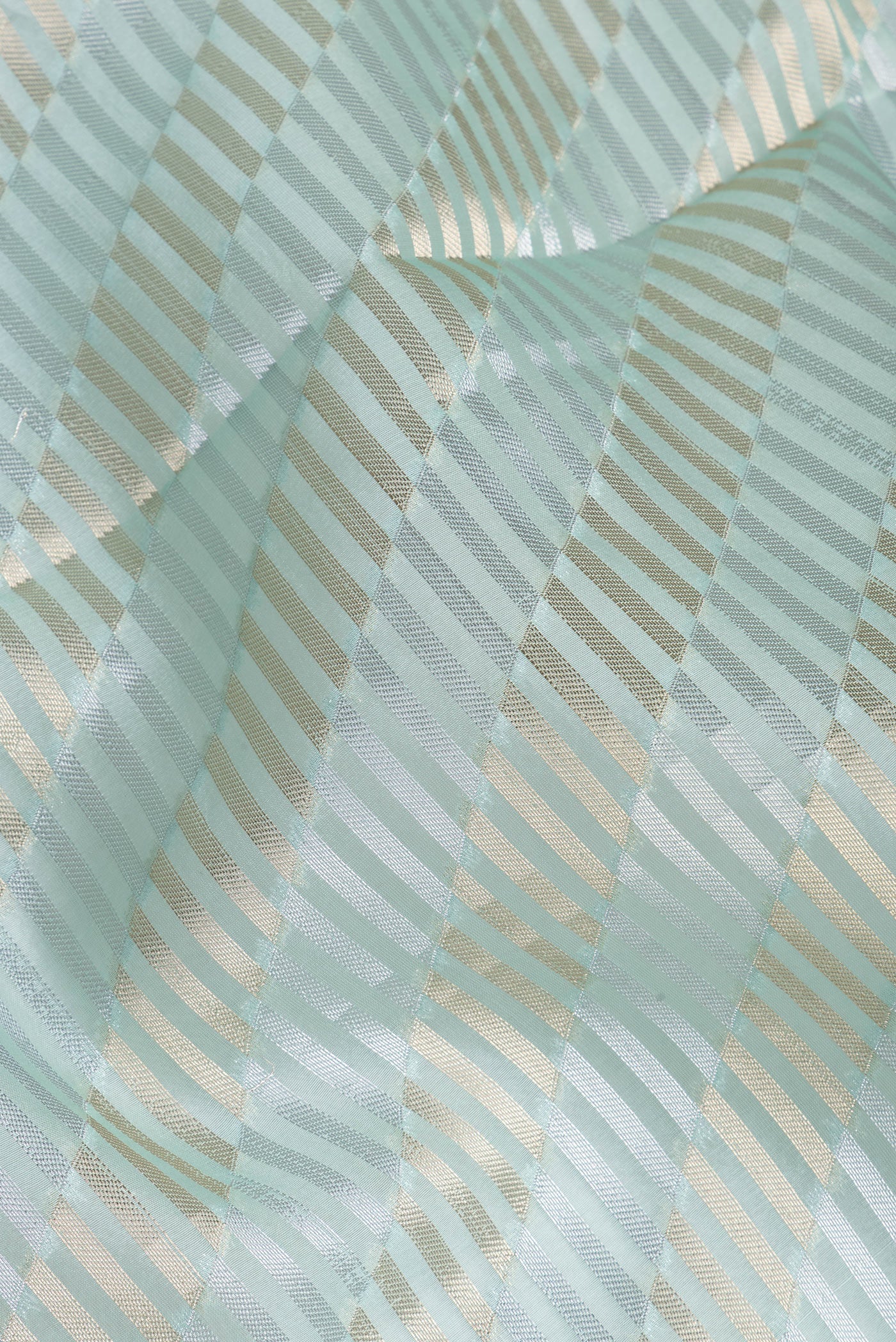 Close up of Sky Blue Organza Silk Saree with Zari Brocade on the body and Sequin Border.  displaying folds
