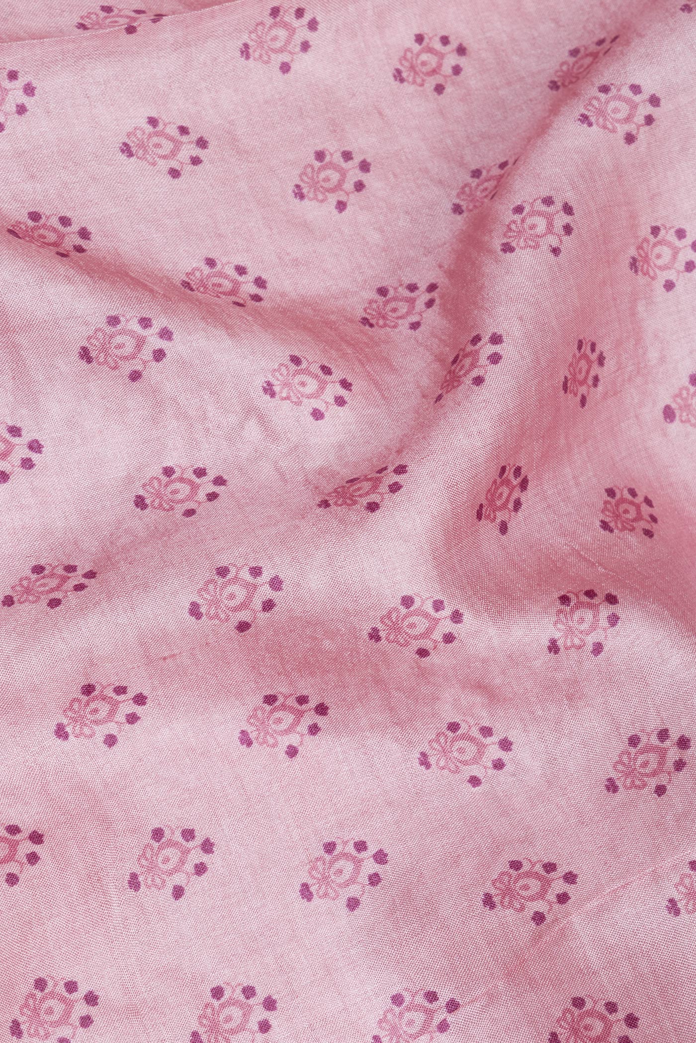 Close up of Pink Tussar Silk Saree with Printed design on the body and Embroidery Border.  displaying folds