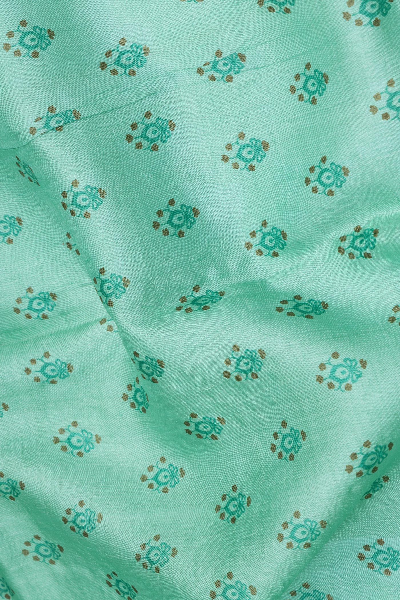 Close up of Sea Green Tussar Silk Saree with Printed design on the body and Embroidery Border.  displaying folds