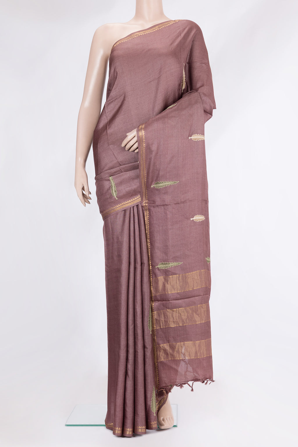 Brown Tussar Silk Saree with Embroidery on the body and Zari Border.  displayed on a mannequin