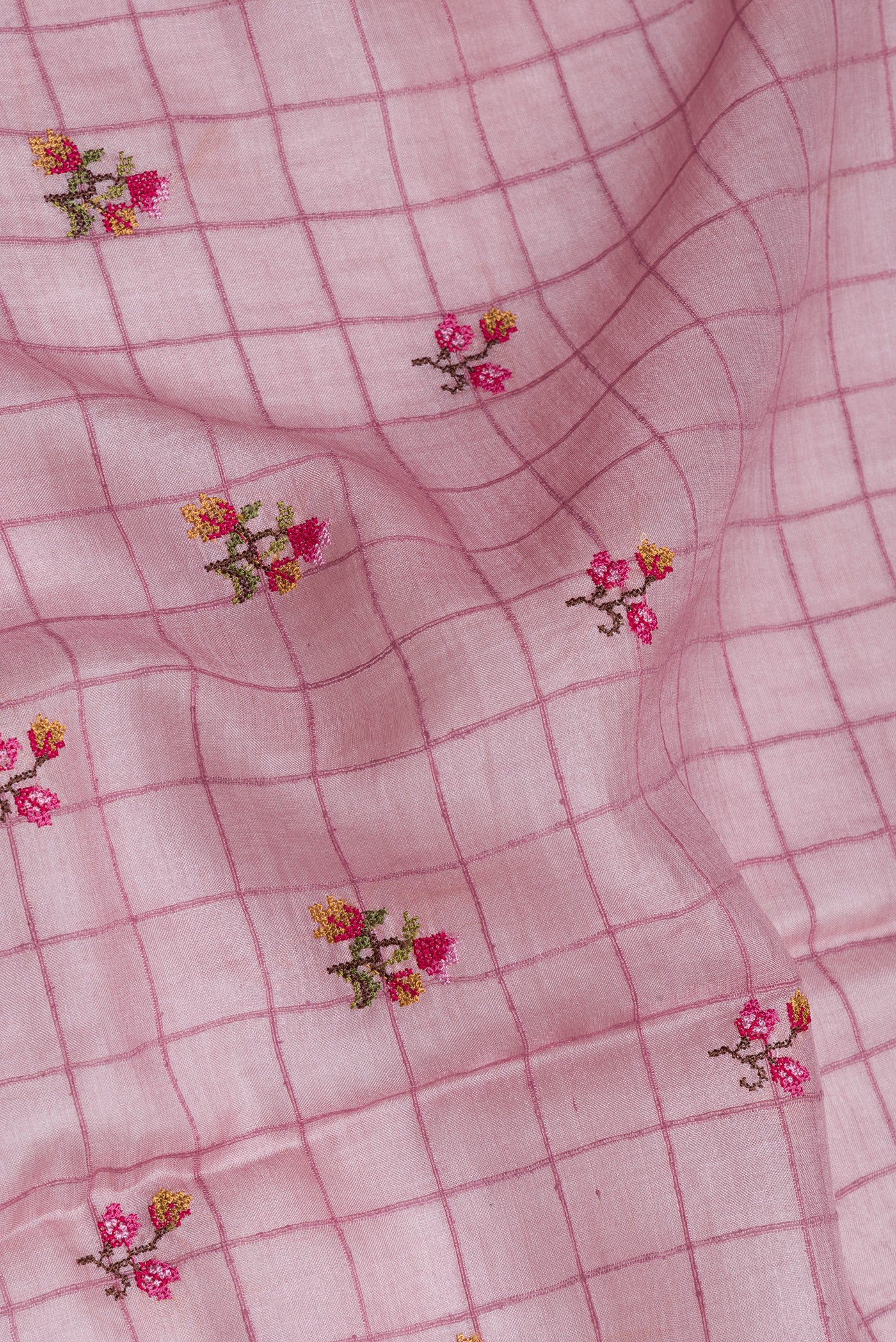 Close up of Pink Tussar Silk Saree with Checked design on the body and Zari Border.  displaying folds