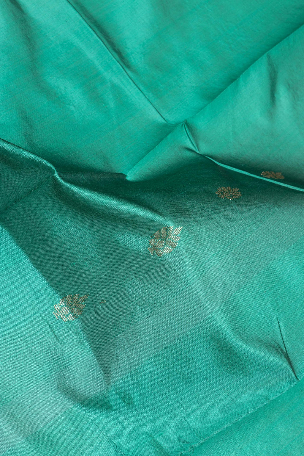 Close up of Green Banarasi Silk Saree with Zari Butta on the body and Zari Border.  displaying folds