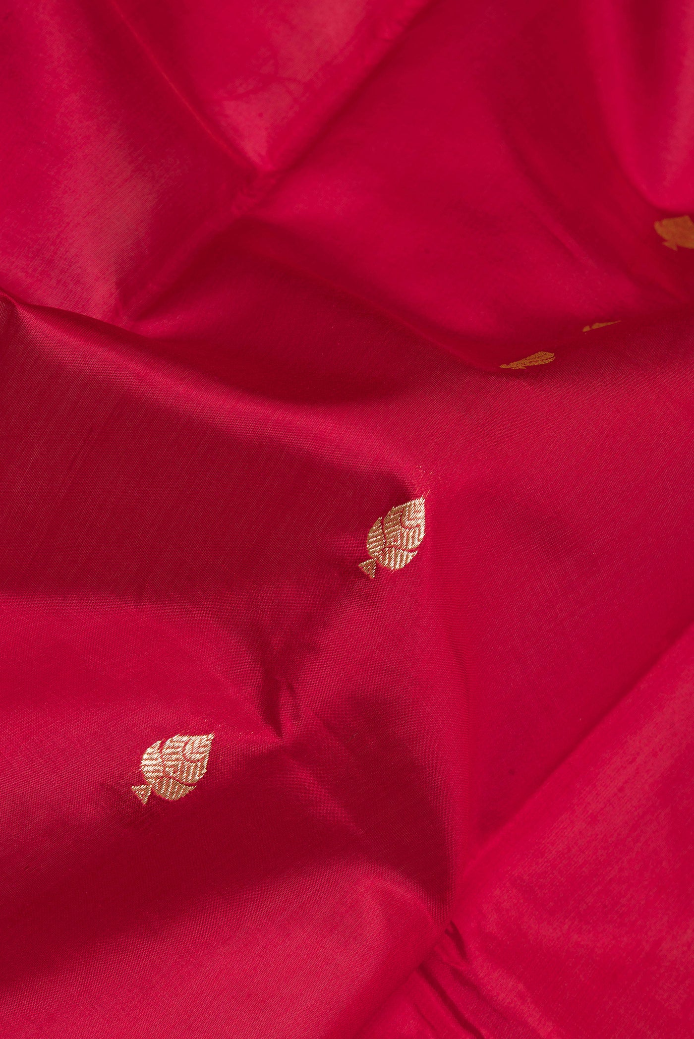 Close up of Maroon Banarasi Silk Saree with Zari Butta on the body and Zari Border.  displaying folds