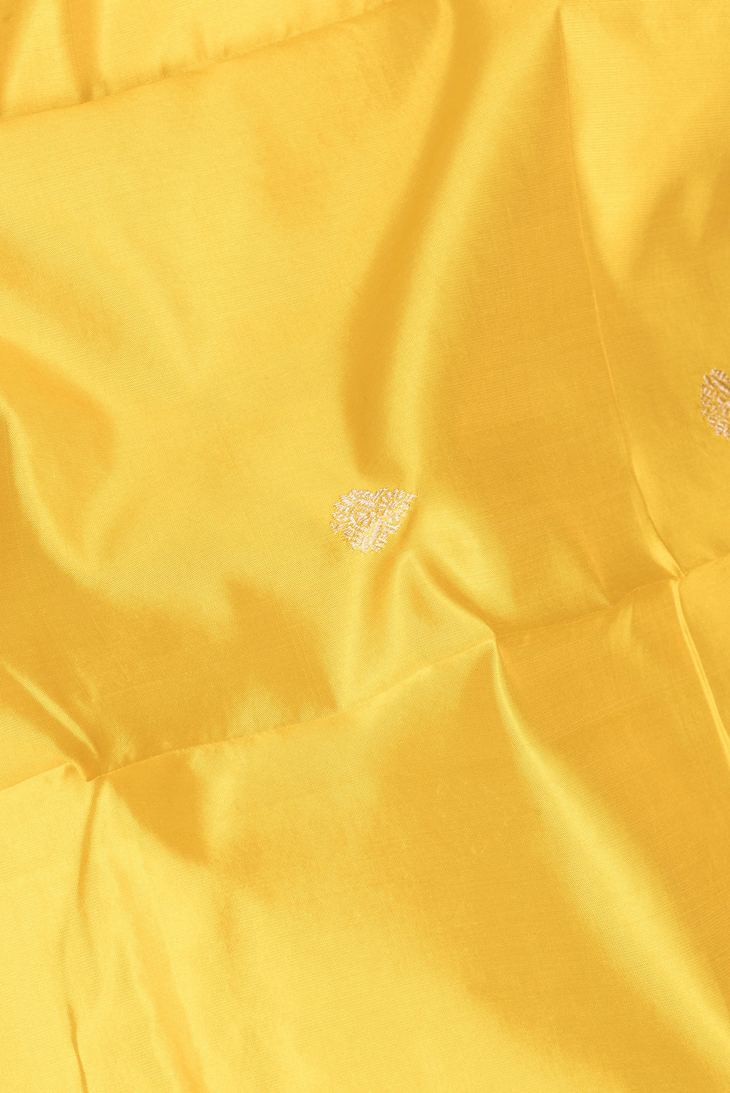 Close up of Yellow Banarasi Silk Saree with Zari Butta on the body and Zari Border.  displaying folds