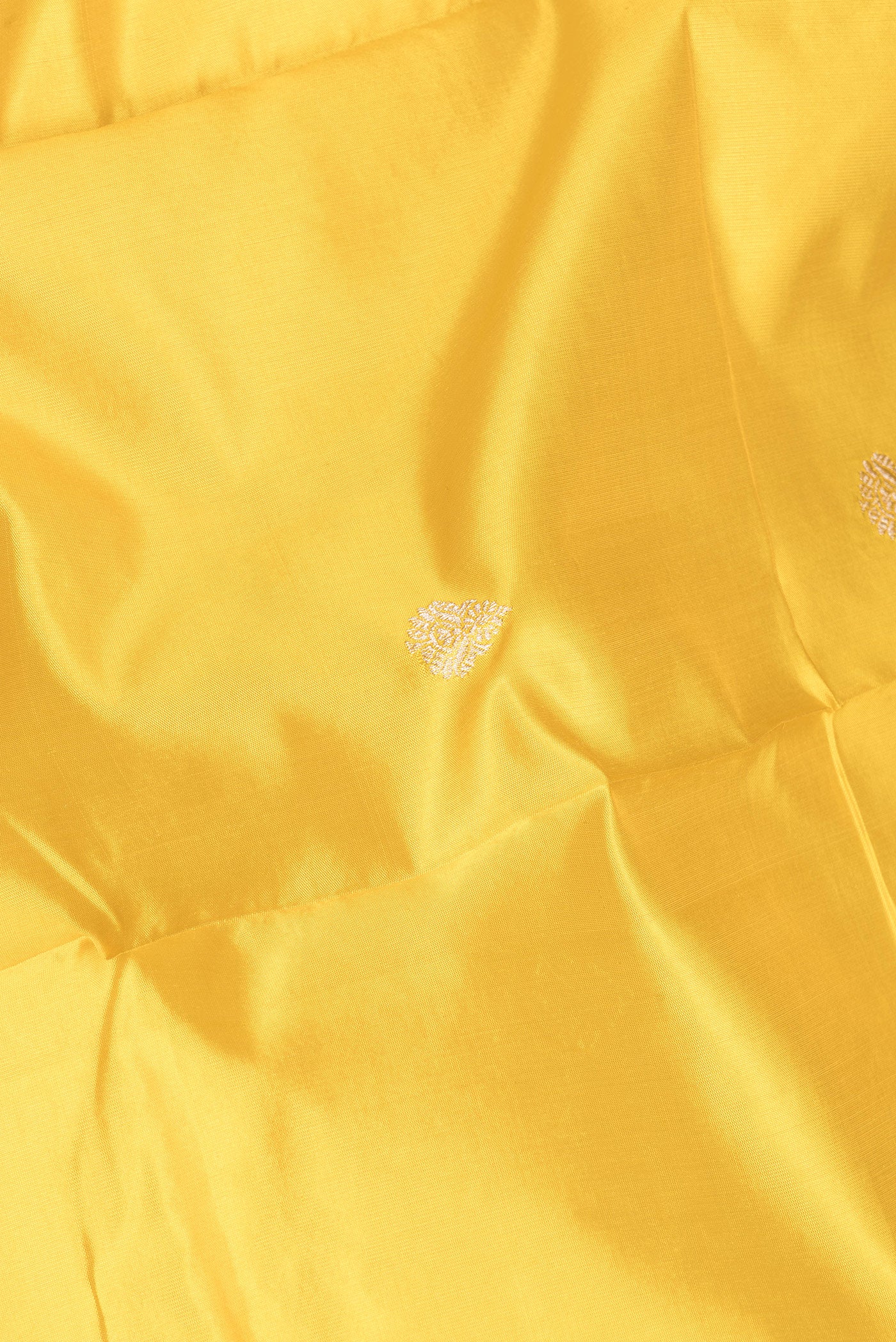 Close up of Yellow Banarasi Silk Saree with Zari Butta on the body and Zari Border.  displaying folds