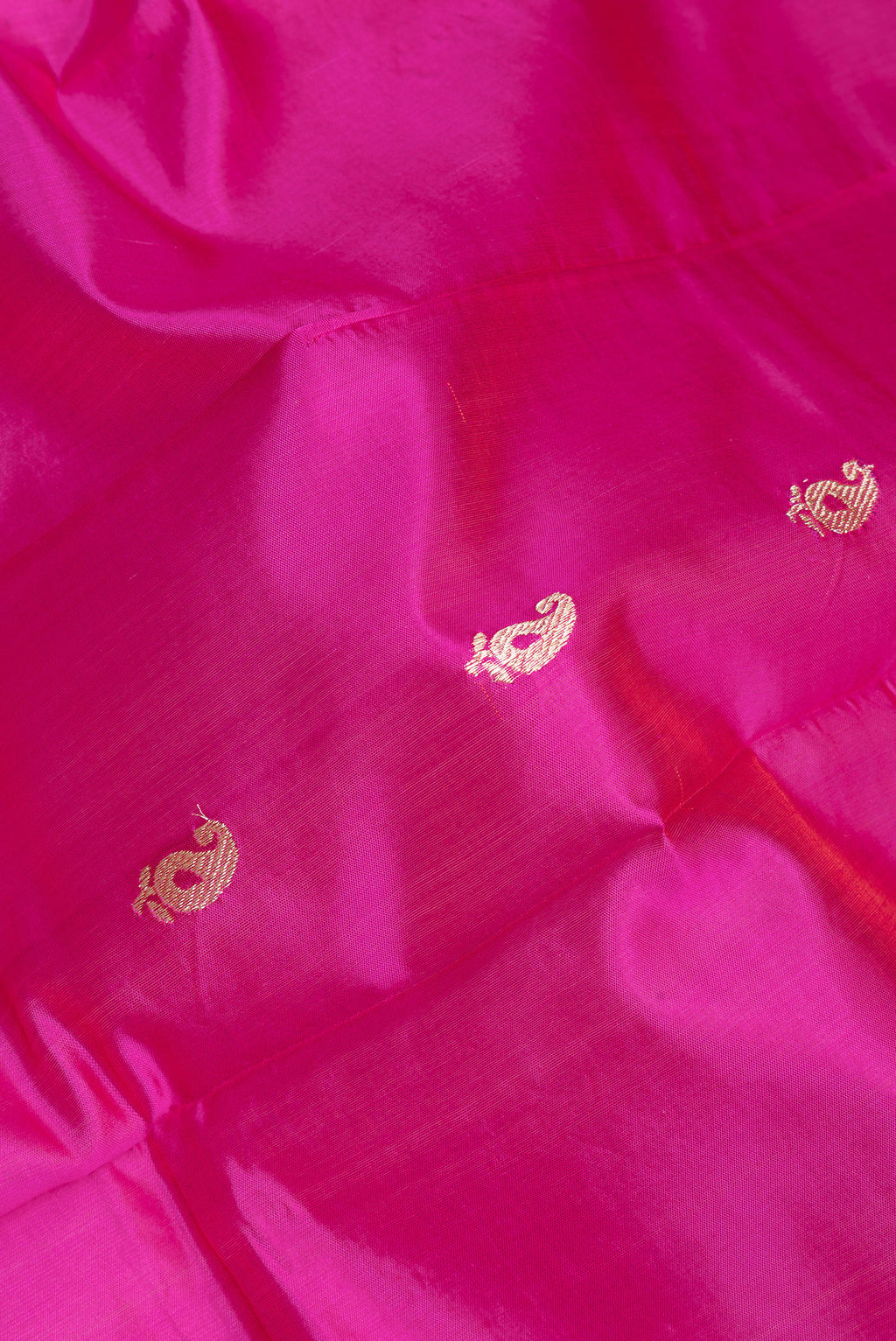 Close up of Dark Pink Banarasi Silk Saree with Zari Butta on the body and Zari Border.  displaying folds