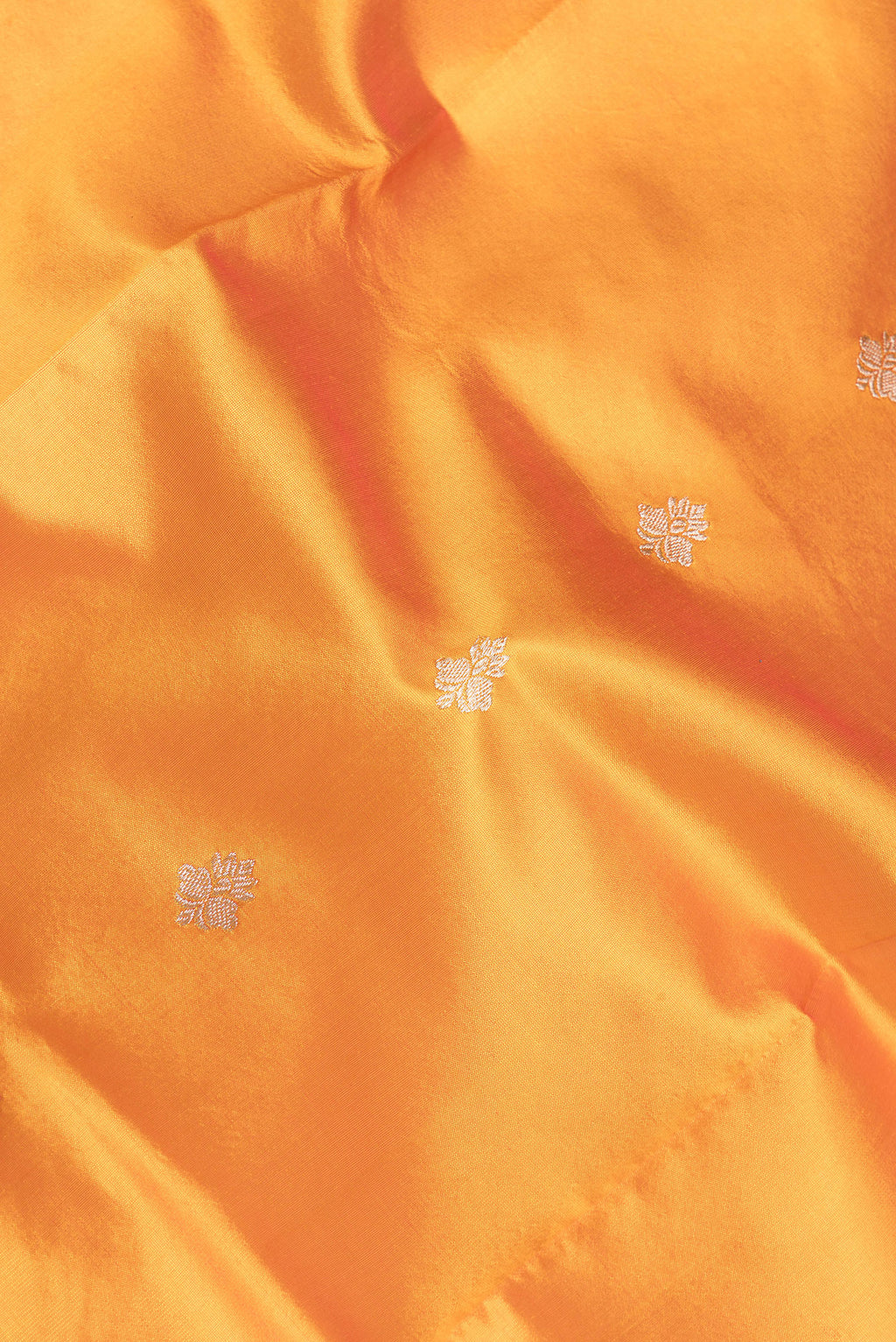 Close up of Orange Banarasi Silk Saree with Zari Butta on the body and Zari Border.  displaying folds