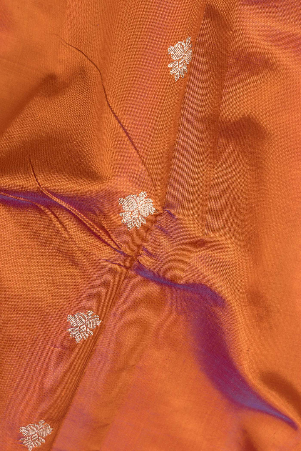 Close up of Pure Silk Rust Banarasi Katan Saree with Zari Butta on the body and Zari Border.  displaying folds