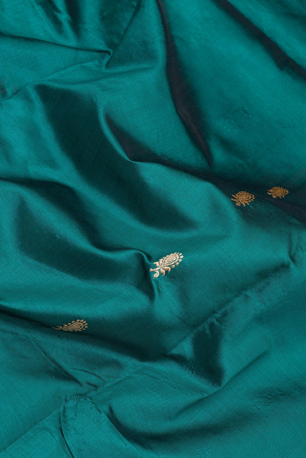 Close up of Bottle Green Banarasi Silk Saree with Zari Butta on the body and Zari Border.  displaying folds