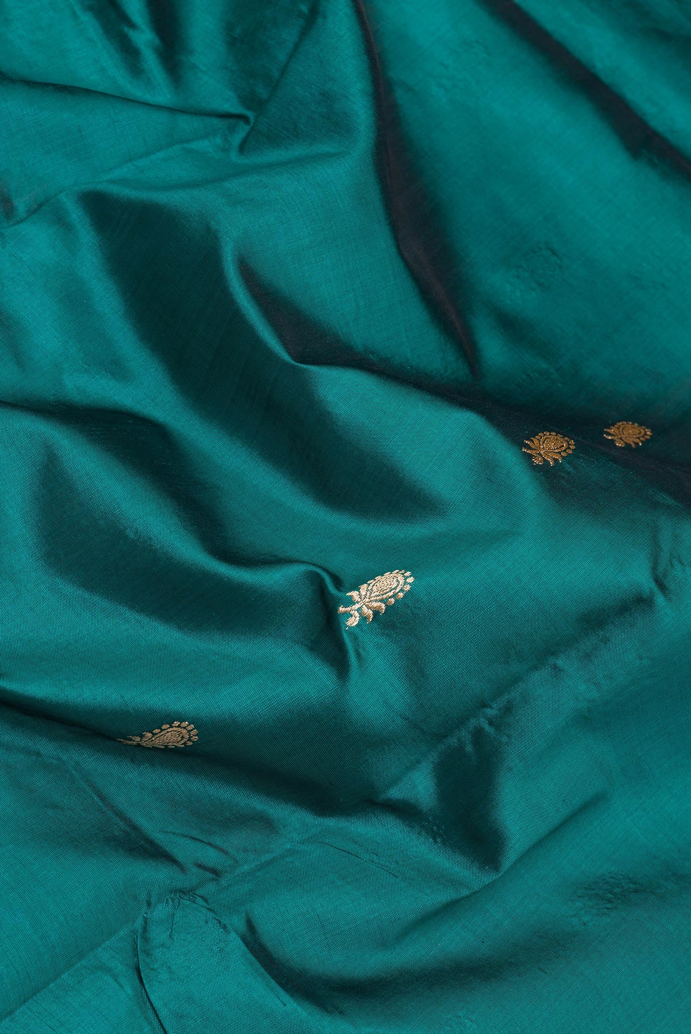 Close up of Bottle Green Banarasi Silk Saree with Zari Butta on the body and Zari Border.  displaying folds
