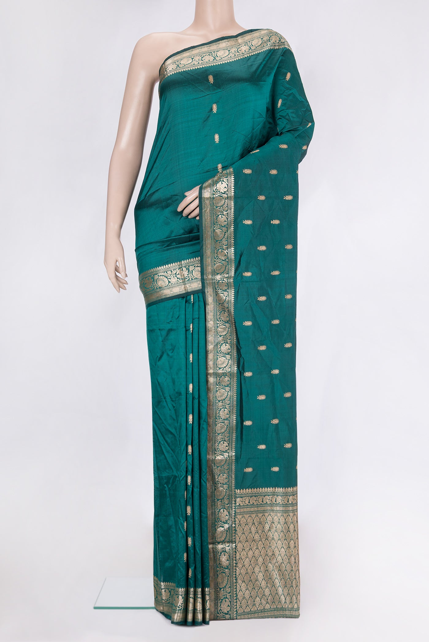 Bottle Green Banarasi Silk Saree with Zari Butta on the body and Zari Border.  displayed on a mannequin