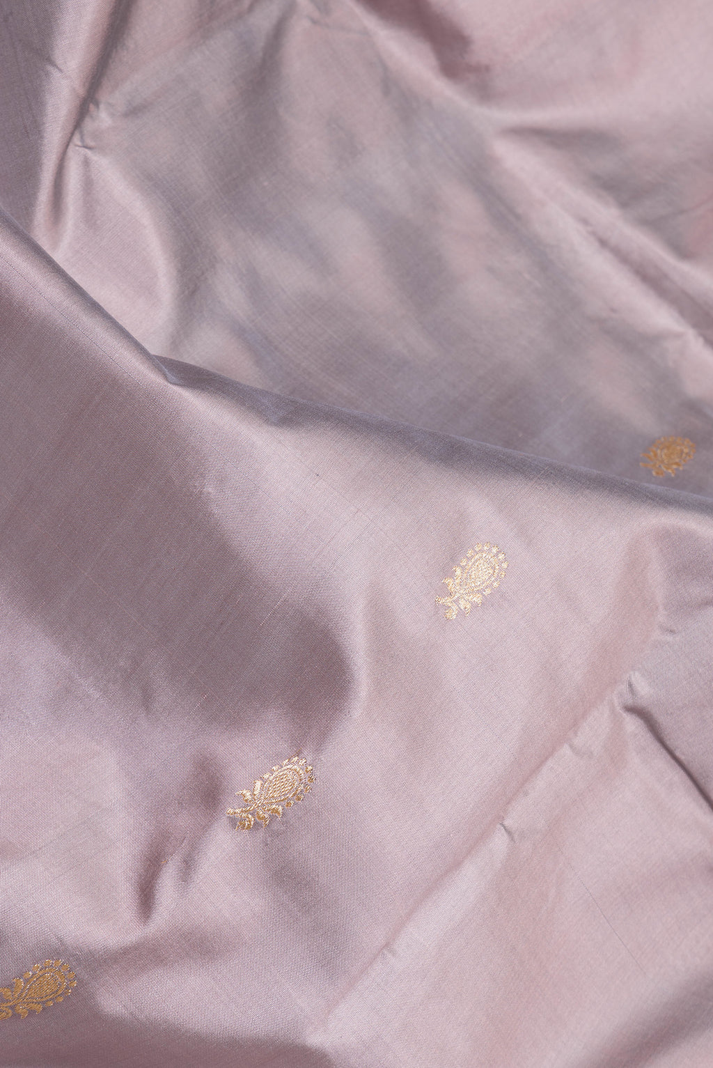 Close up of Lilac Banarasi Silk Saree with Zari Butta on the body and Zari Border.  displaying folds
