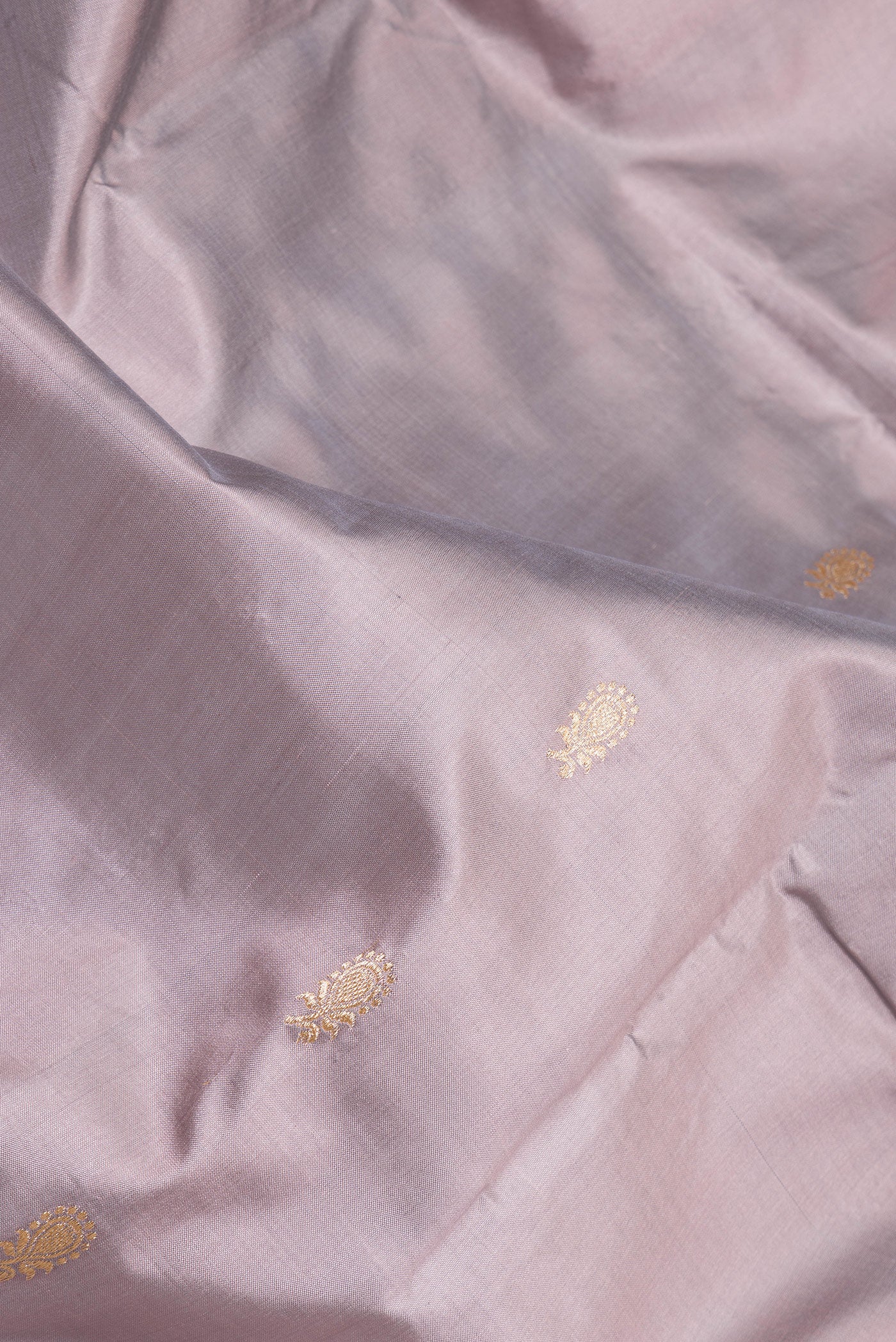 Close up of Lilac Banarasi Silk Saree with Zari Butta on the body and Zari Border.  displaying folds