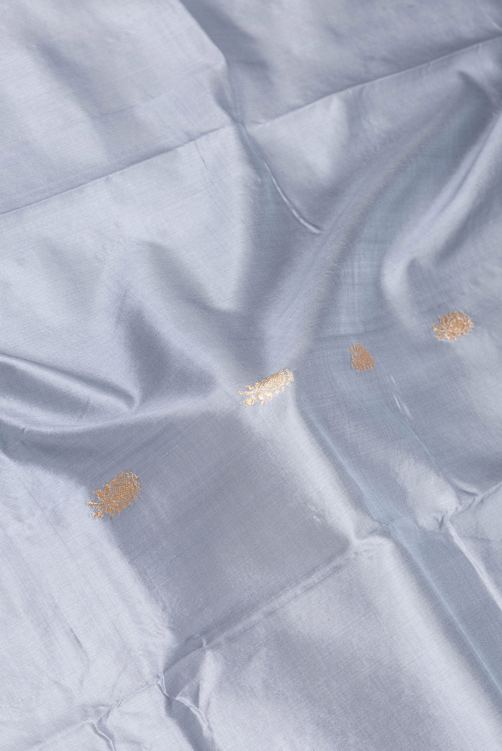 Close up of Grey Banarasi Silk Saree with Zari Butta on the body and Zari Border.  displaying folds