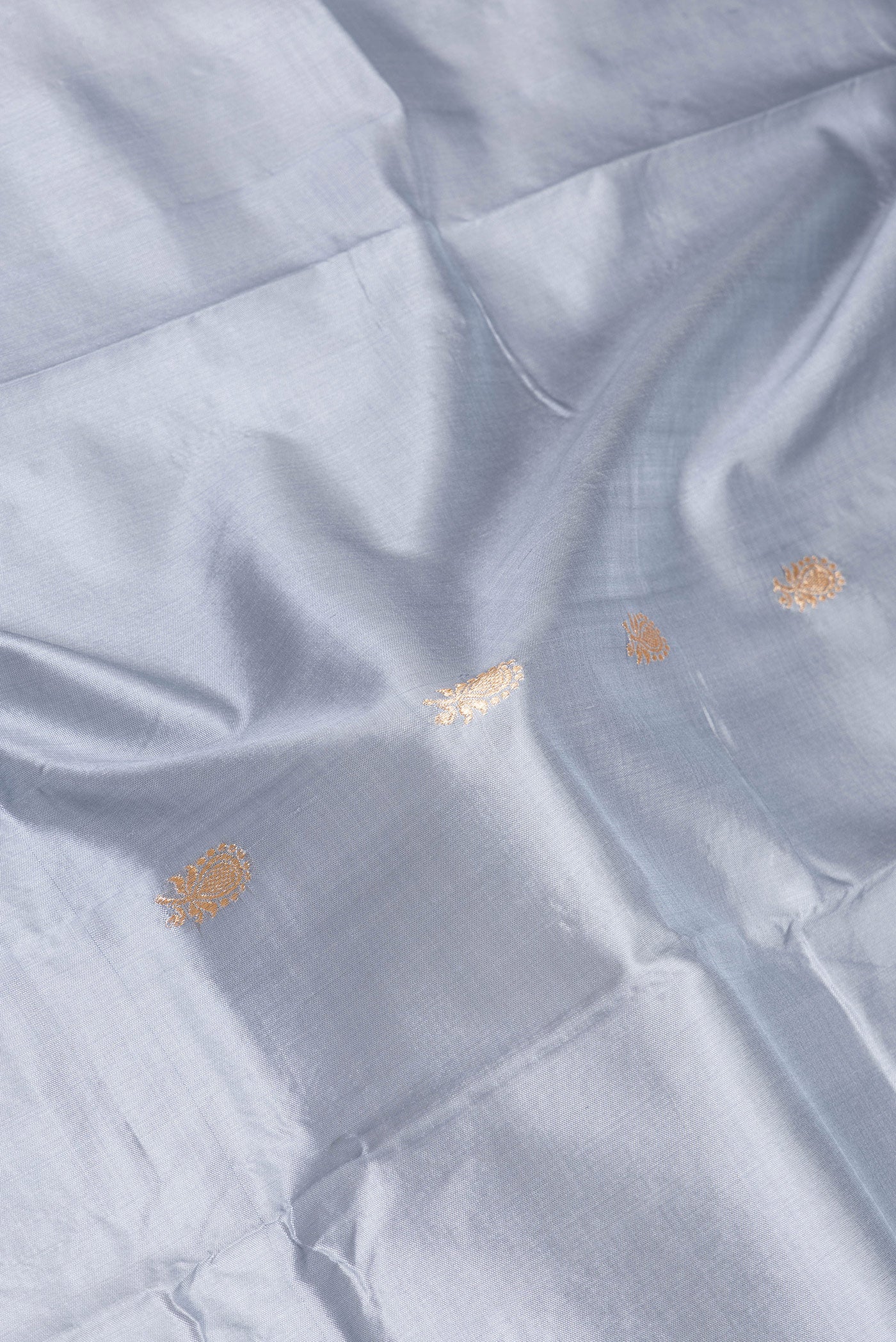 Close up of Grey Banarasi Silk Saree with Zari Butta on the body and Zari Border.  displaying folds