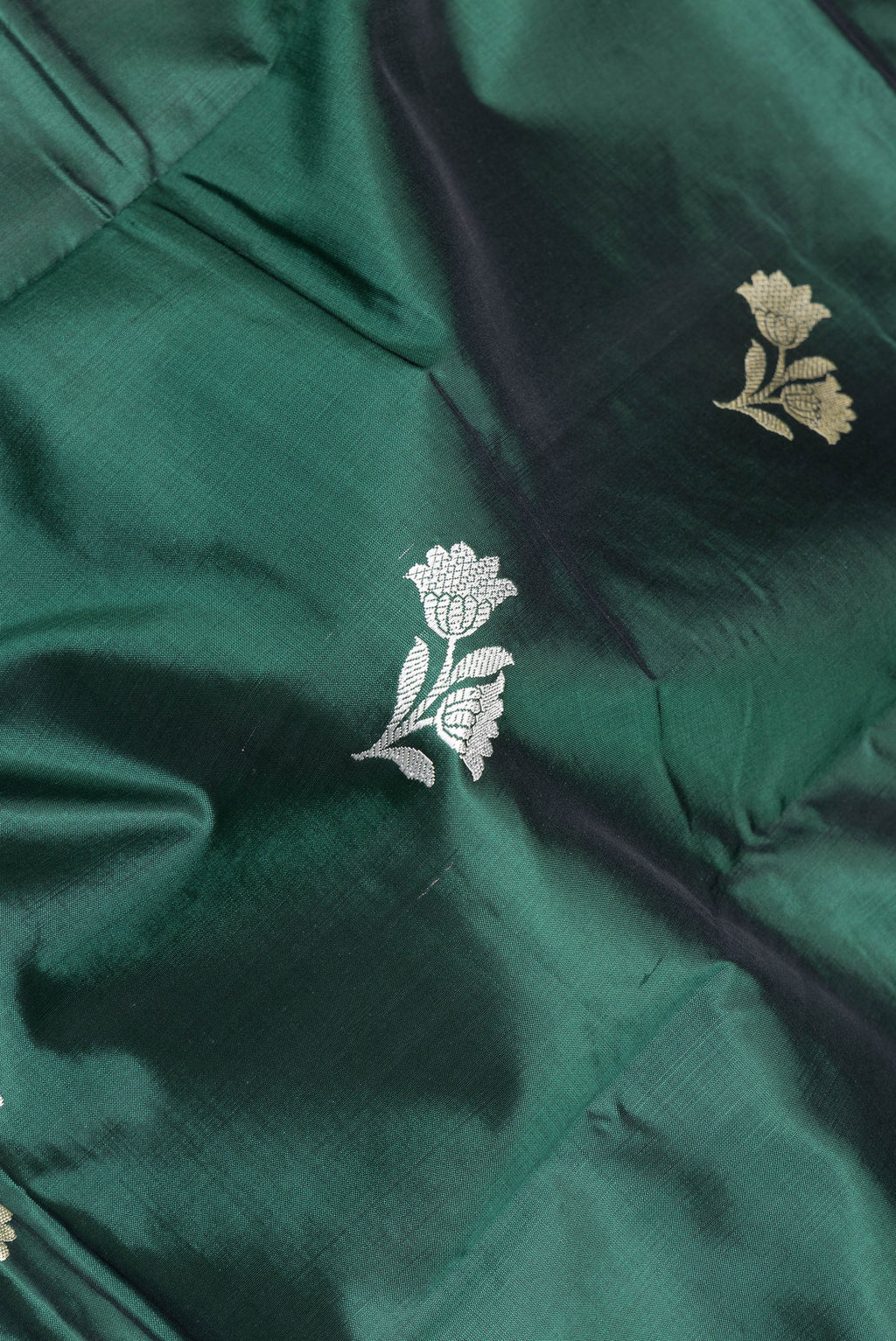 Close up of Bottle Green Banarasi Silk Saree with Thread Butta on the body and Thread Border.  displaying folds