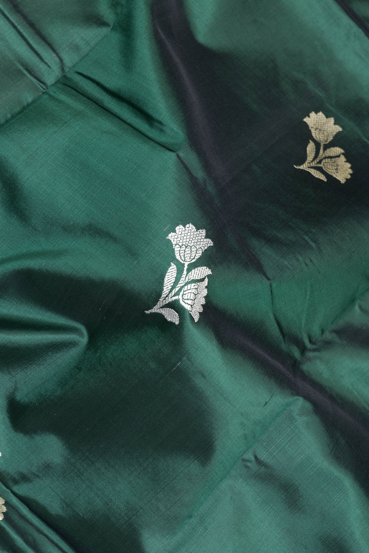 Close up of Bottle Green Banarasi Silk Saree with Thread Butta on the body and Thread Border.  displaying folds