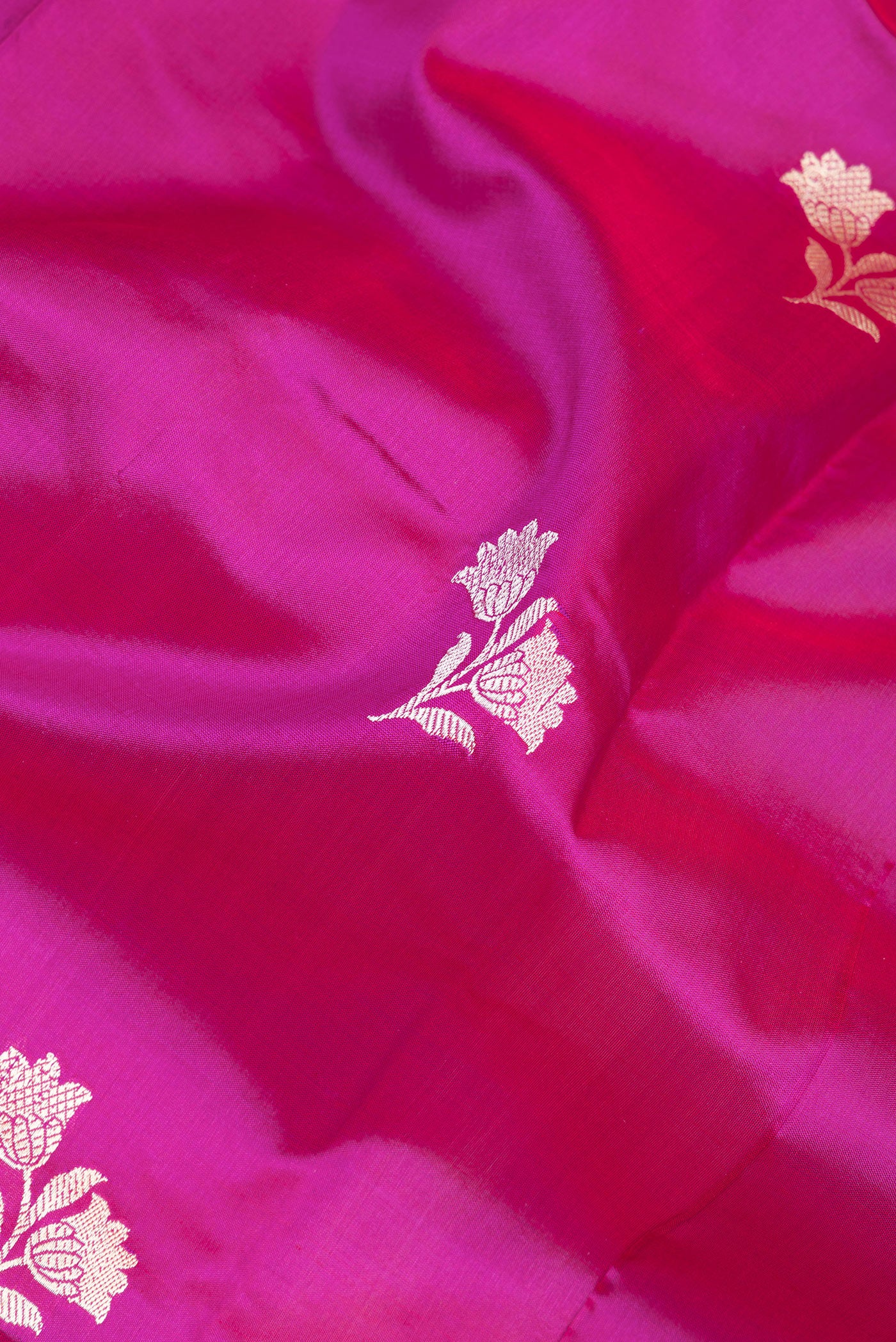 Close up of Magenta Banarasi Silk Saree with Thread Butta on the body and Thread Border.  displaying folds