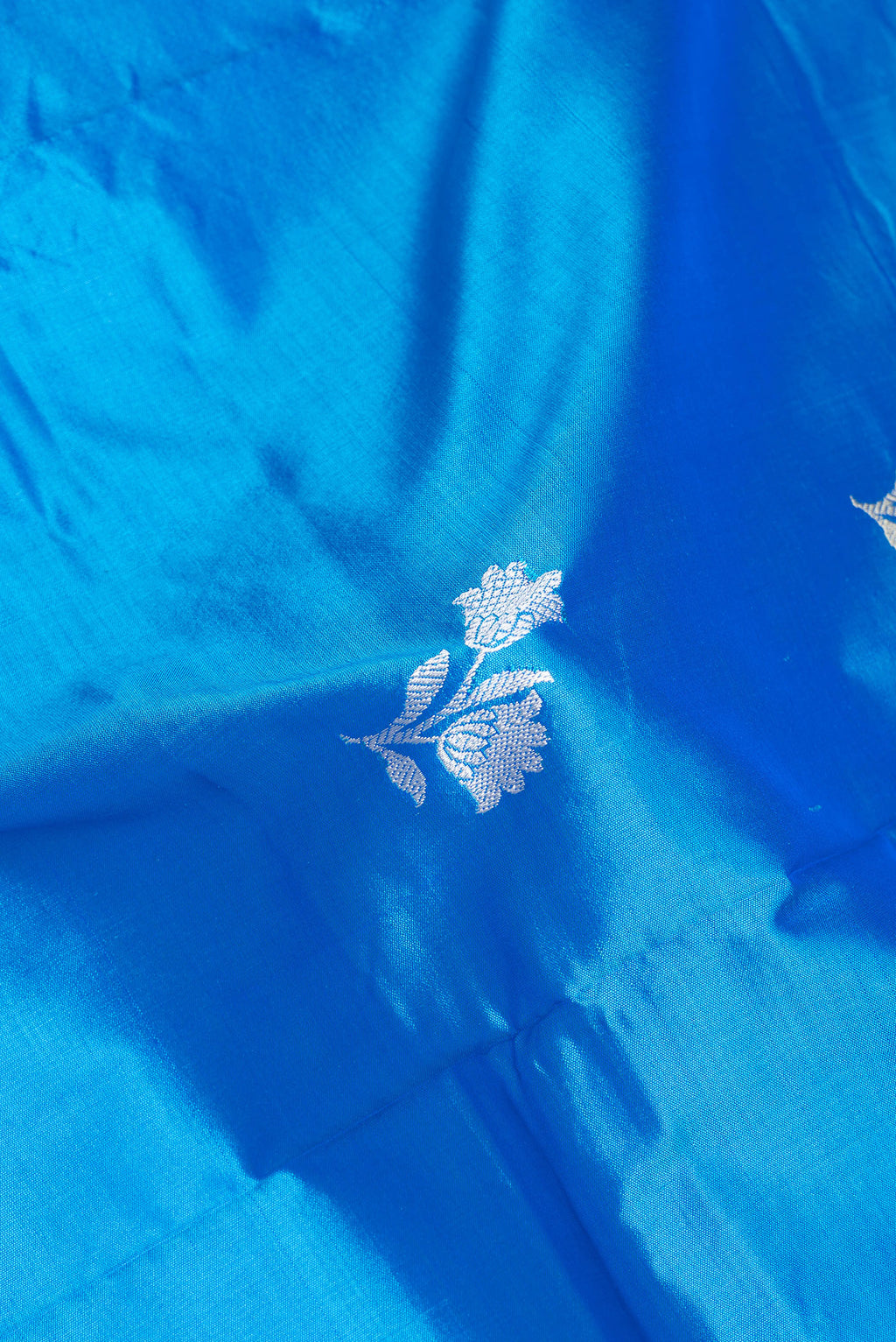 Close up of Royal Blue Banarasi Silk Saree with Thread Butta on the body and Thread Border.  displaying folds