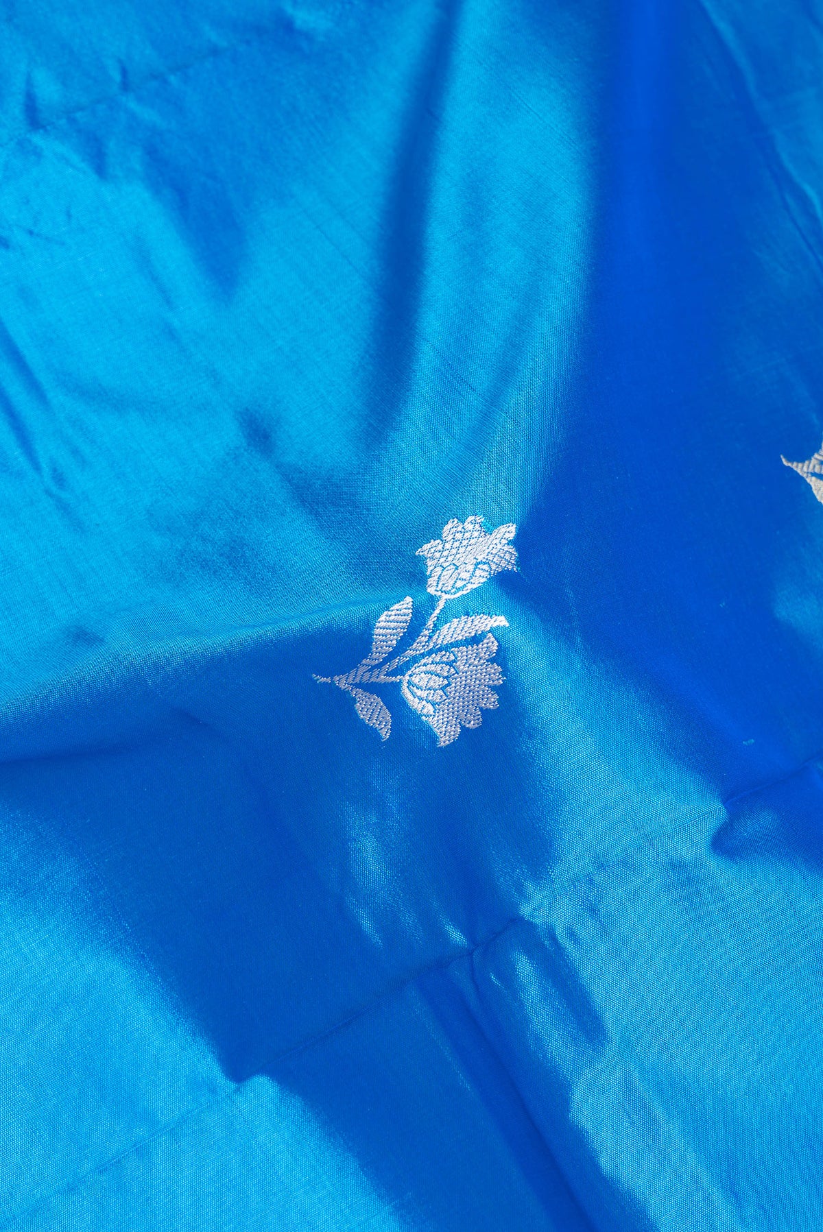 Close up of Royal Blue Banarasi Silk Saree with Thread Butta on the body and Thread Border.  displaying folds