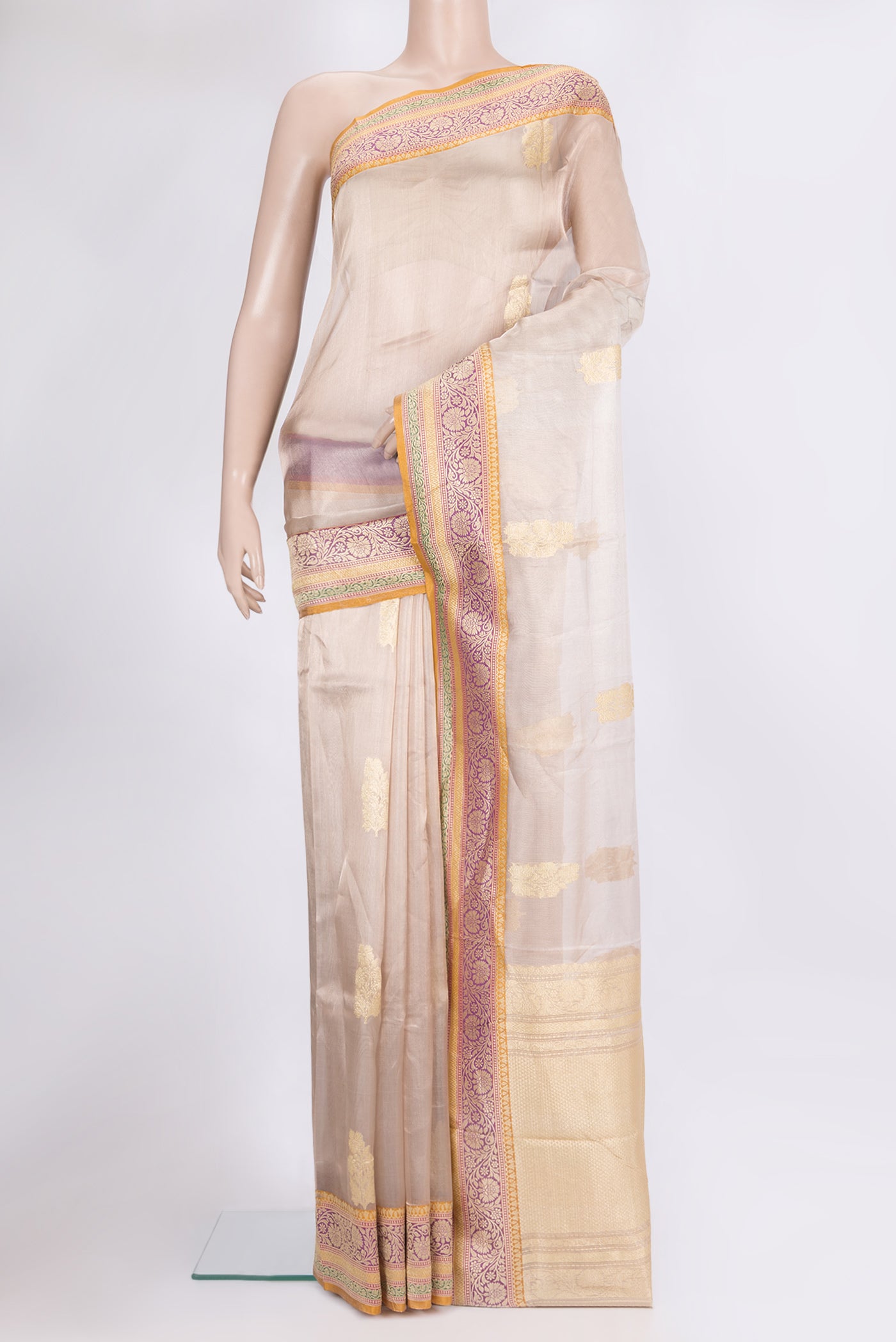 Rose Gold Organza Saree with Zari Butta on the body and Zari Border.  displayed on a mannequin