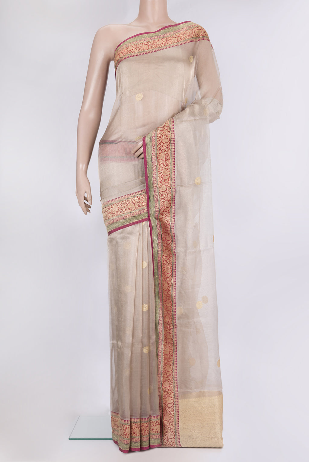 Beige Organza Saree with Zari Butta on the body and Zari Border.  displayed on a mannequin