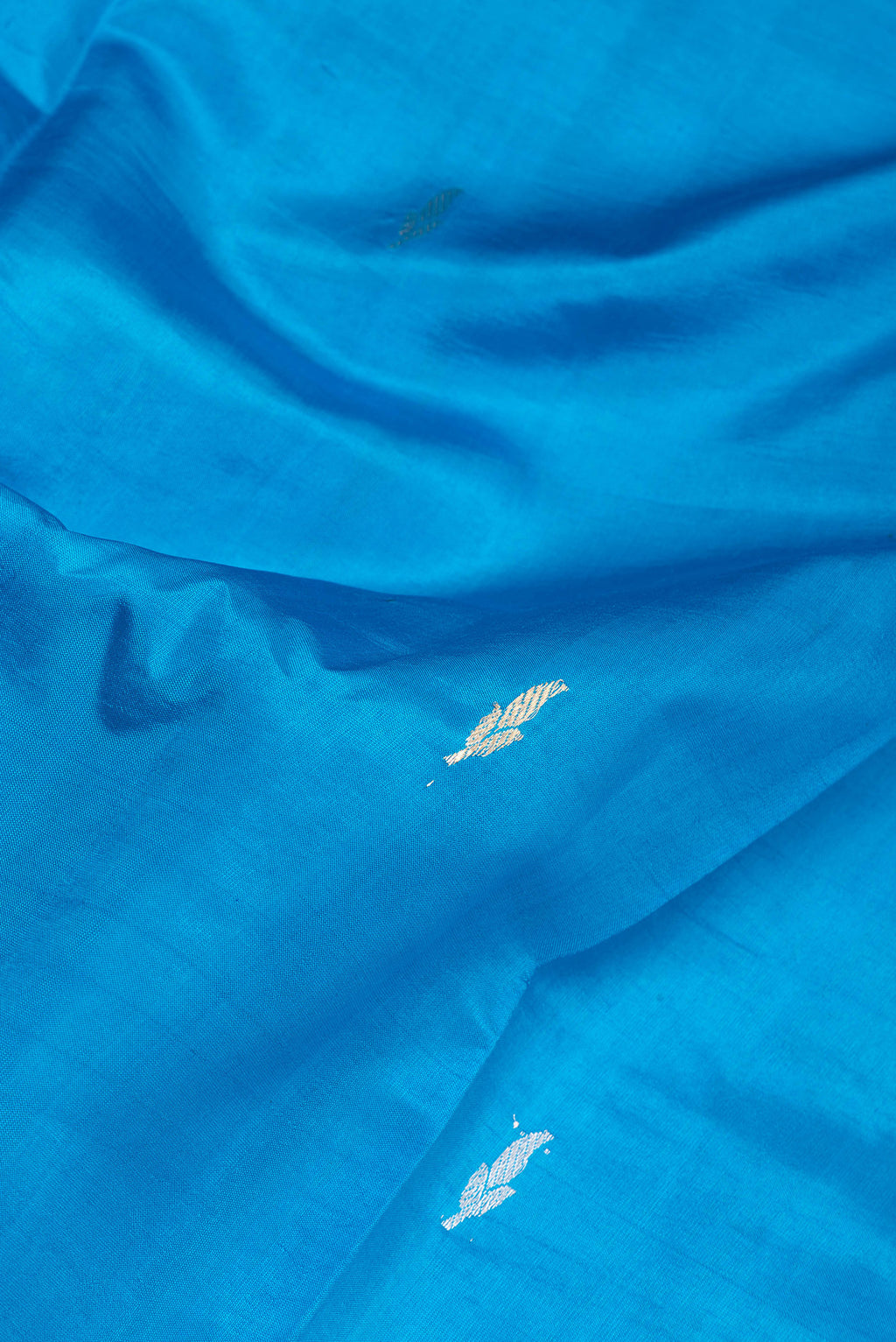 Close up of Sky Blue Banarasi Silk Saree with Zari Butta on the body and Zari Border.  displaying folds