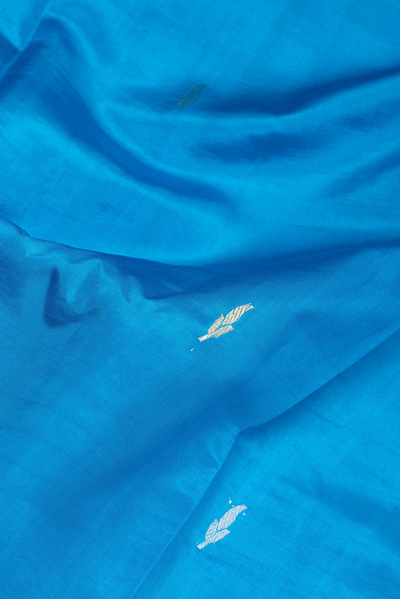 Close up of Sky Blue Banarasi Silk Saree with Zari Butta on the body and Zari Border.  displaying folds