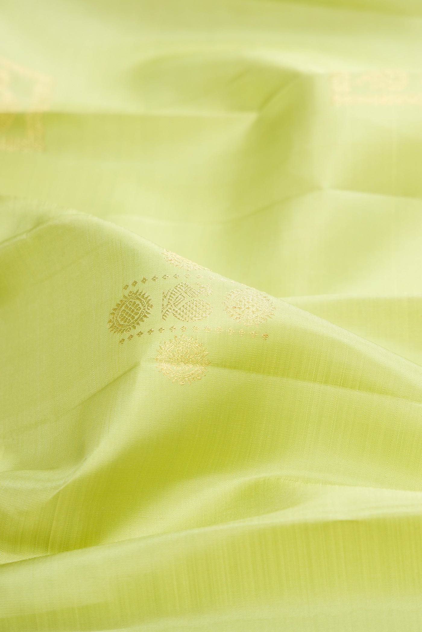 Close up of Pure Silk Pista Green Kanjivaram Saree with Zari Butta on the body and Zari Border.  displaying folds