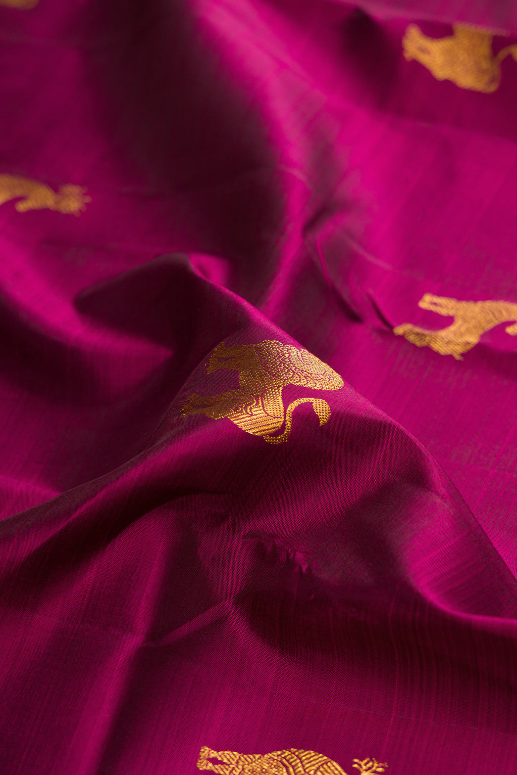 Close up of Pure Silk Magenta Kanjivaram Saree with Zari Butta on the body and Zari Border.  displaying folds