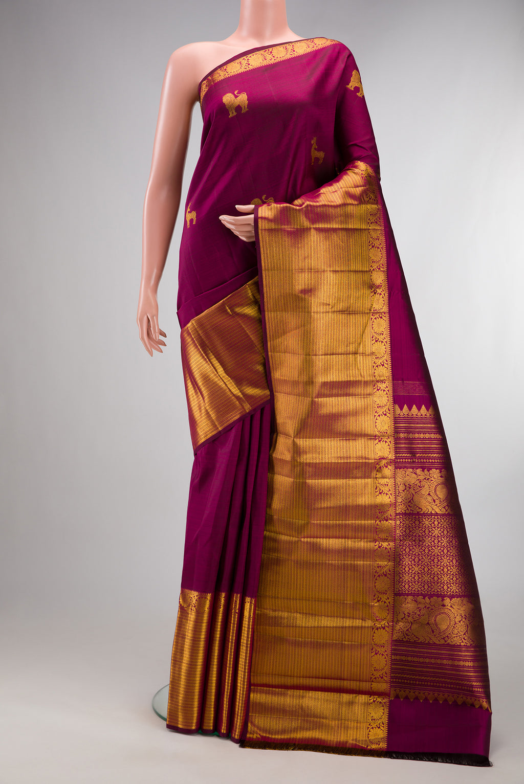 Pure Silk Magenta Kanjivaram Saree with Zari Butta on the body and Zari Border.  displayed on a mannequin