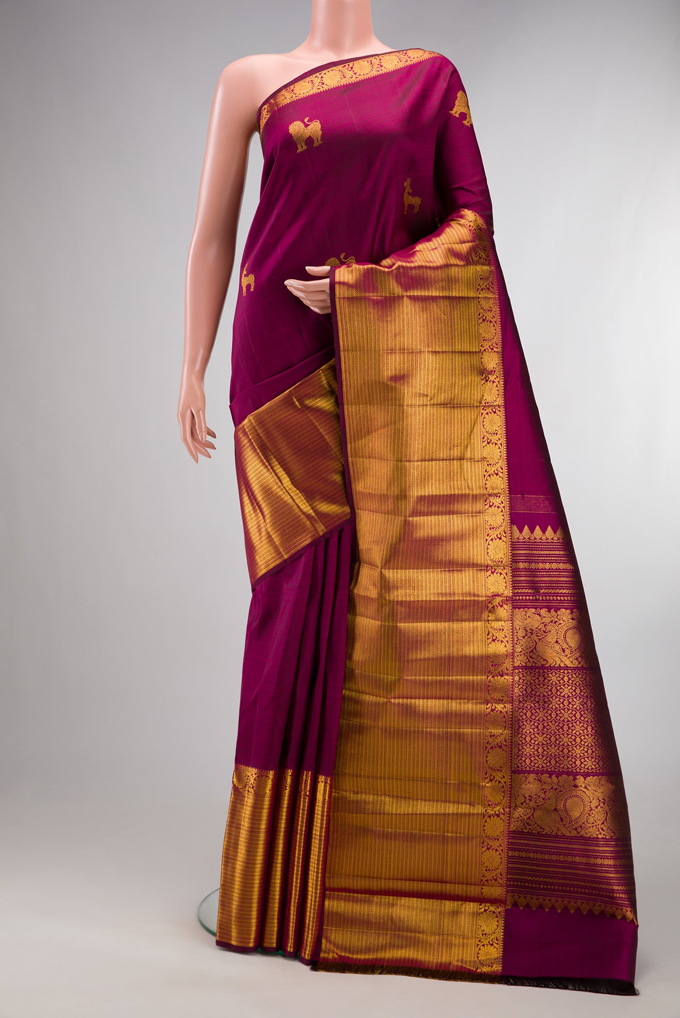Pure Silk Magenta Kanjivaram Saree with Zari Butta on the body and Zari Border.  displayed on a mannequin