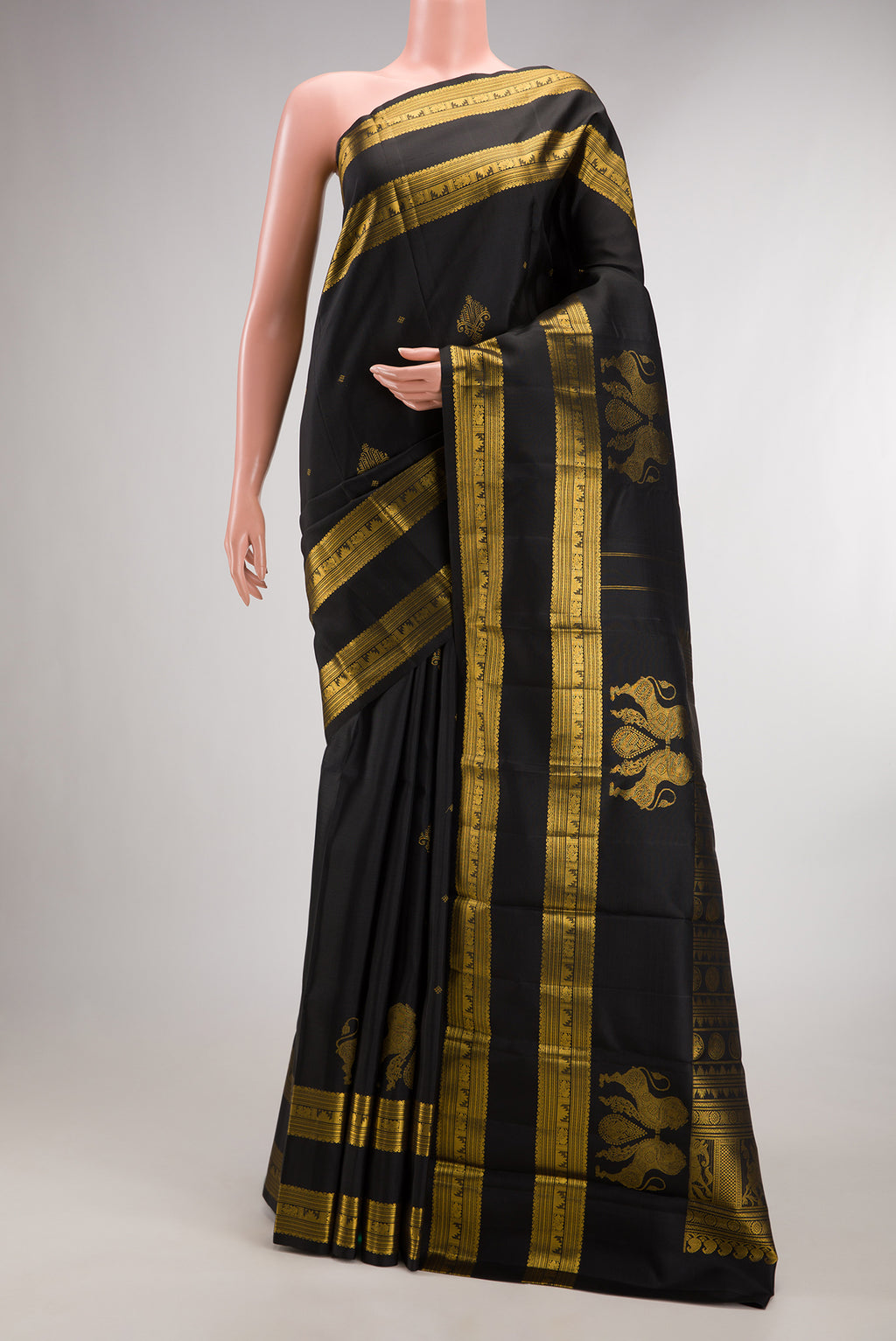 Pure Silk Black Kanjivaram Saree with Zari Butta on the body and Zari Border.  displayed on a mannequin