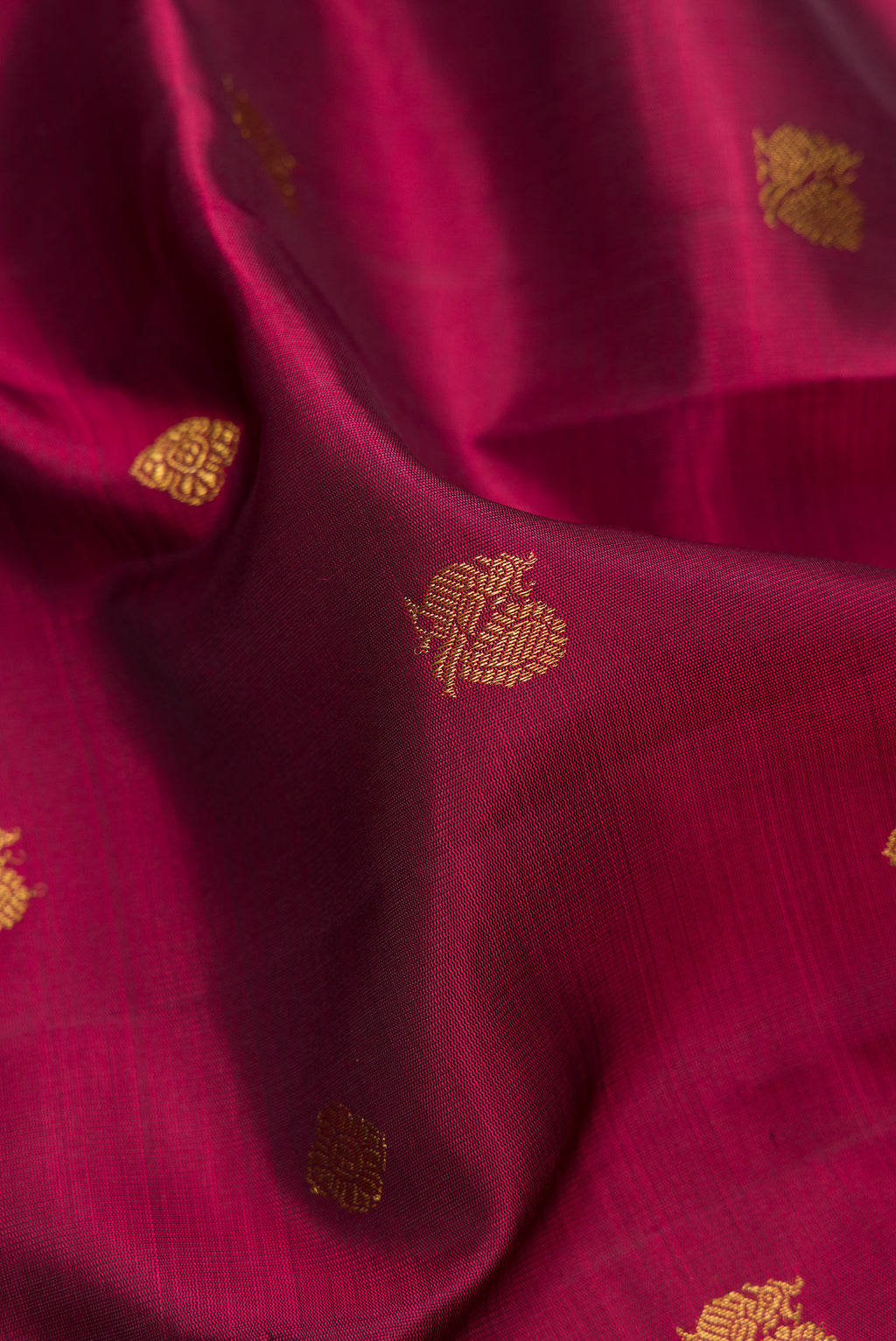 Close up of Pure Silk Pure Zari Maroon Dual Tone Kanjivaram Saree with Zari Butta on the body and Zari Border.  displaying folds