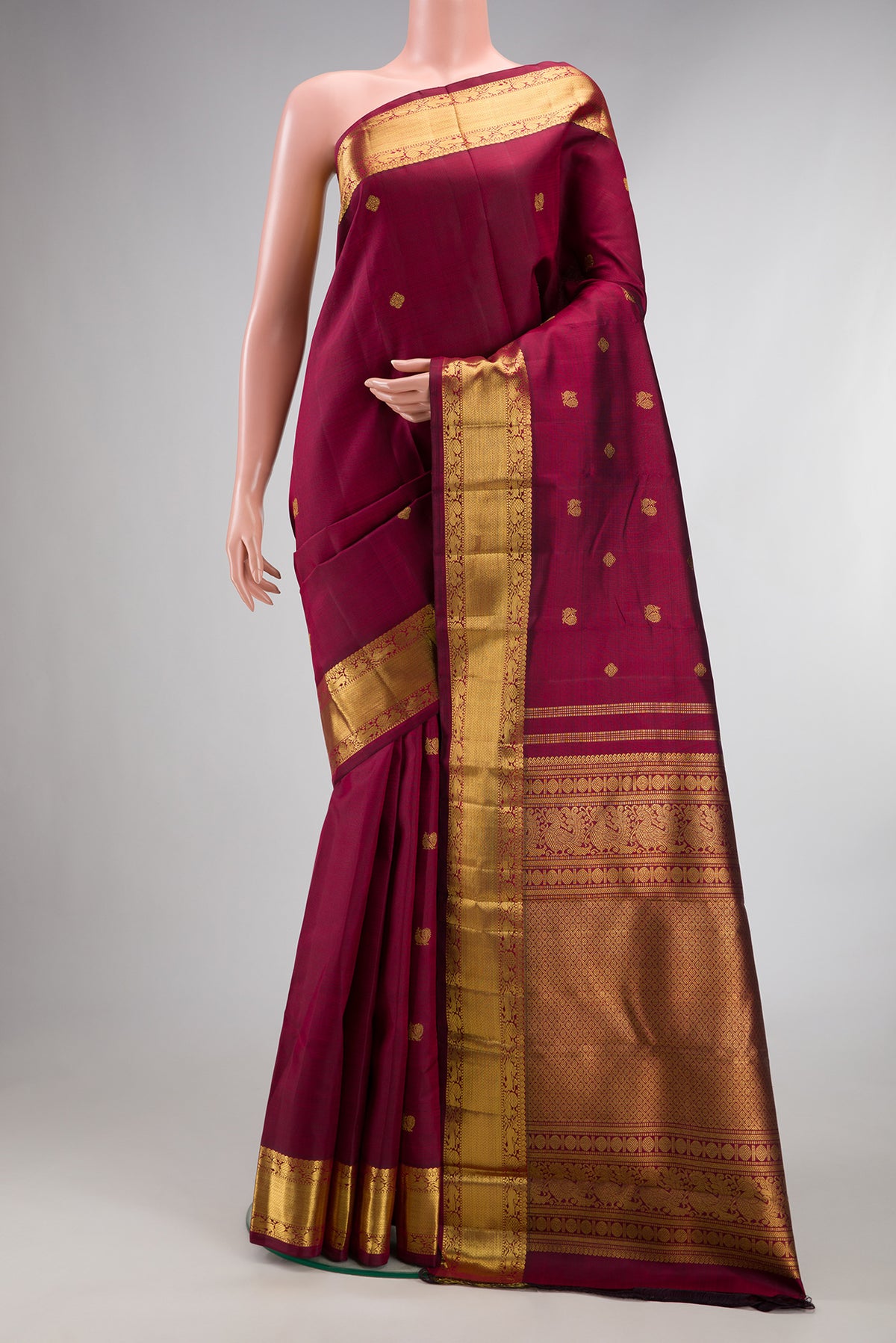 Pure Silk Pure Zari Maroon Dual Tone Kanjivaram Saree with Zari Butta on the body and Zari Border.  displayed on a mannequin