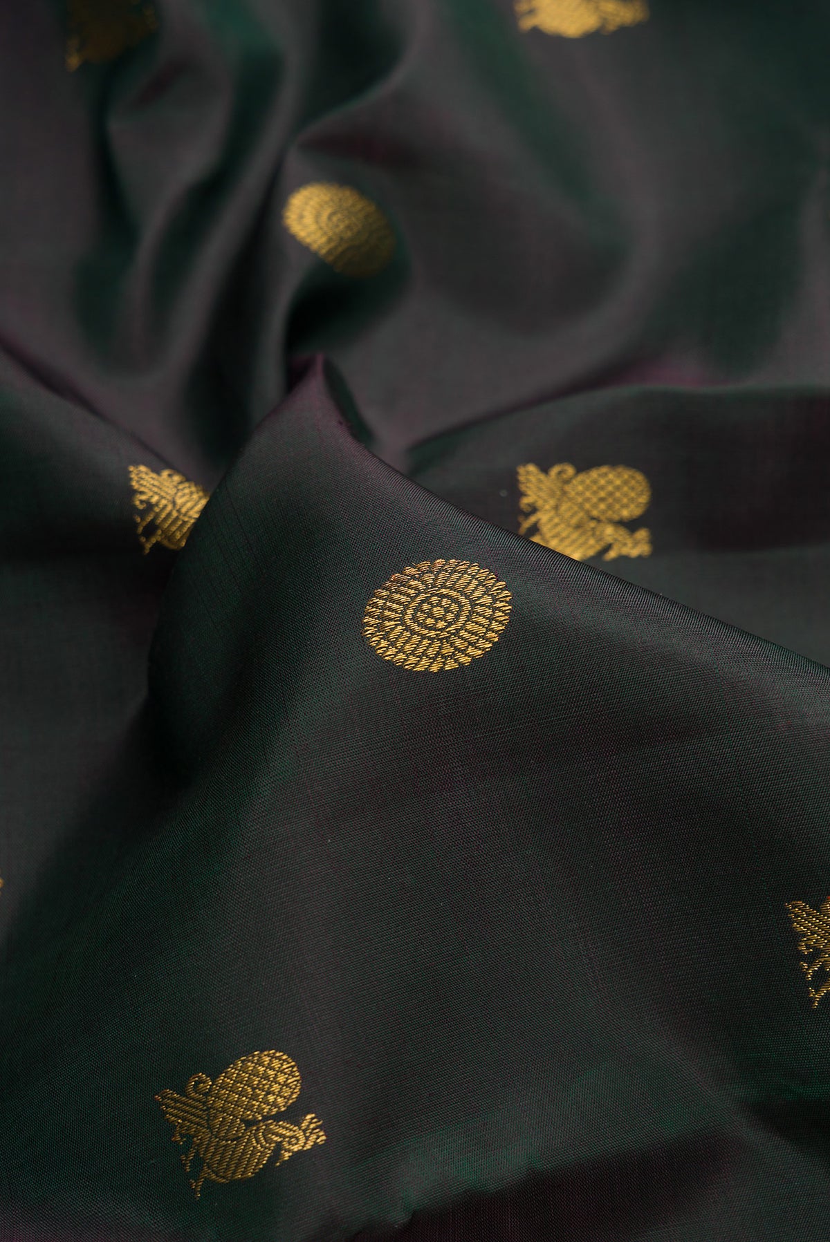 Close up of Pure Silk Pure Zari Bottle Green Dual Tone Kanjivaram Saree with Zari Butta on the body and Zari Border.  displaying folds