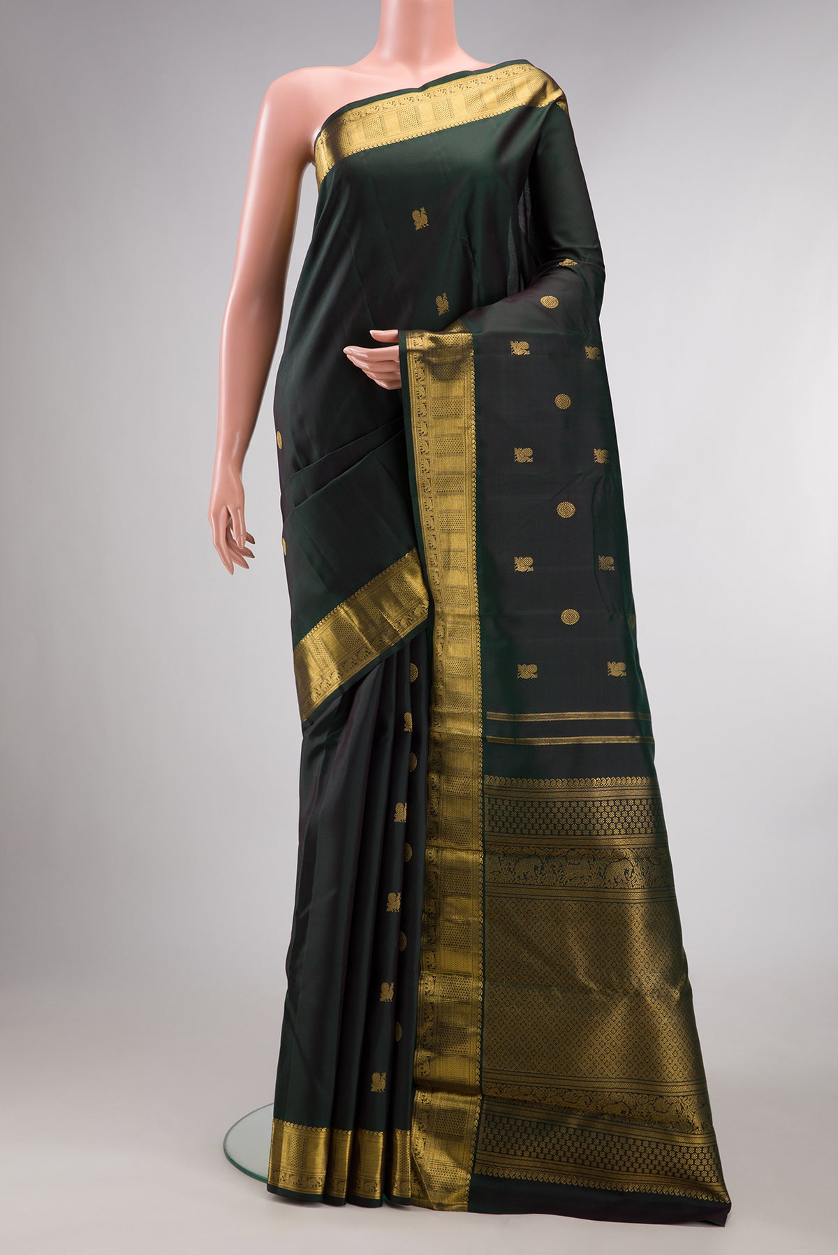 Pure Silk Pure Zari Bottle Green Dual Tone Kanjivaram Saree with Zari Butta on the body and Zari Border.  displayed on a mannequin