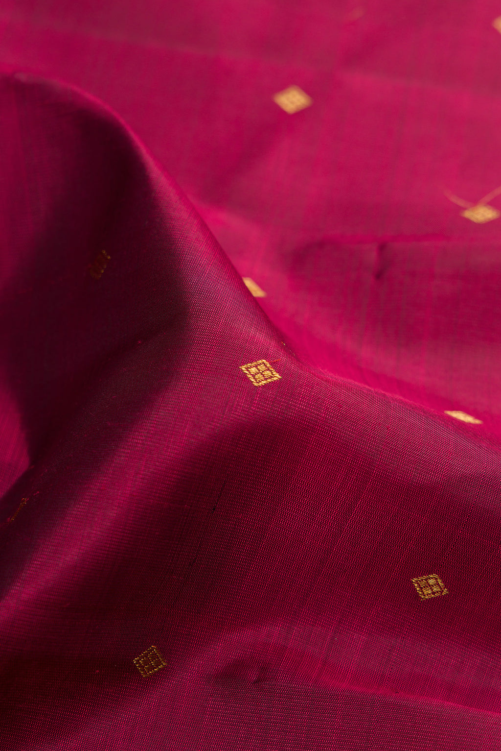 Close up of Pure Silk Pure Zari Maroon Kanchipuram Saree with Zari Butta on the body and Fancy Border.  displaying folds